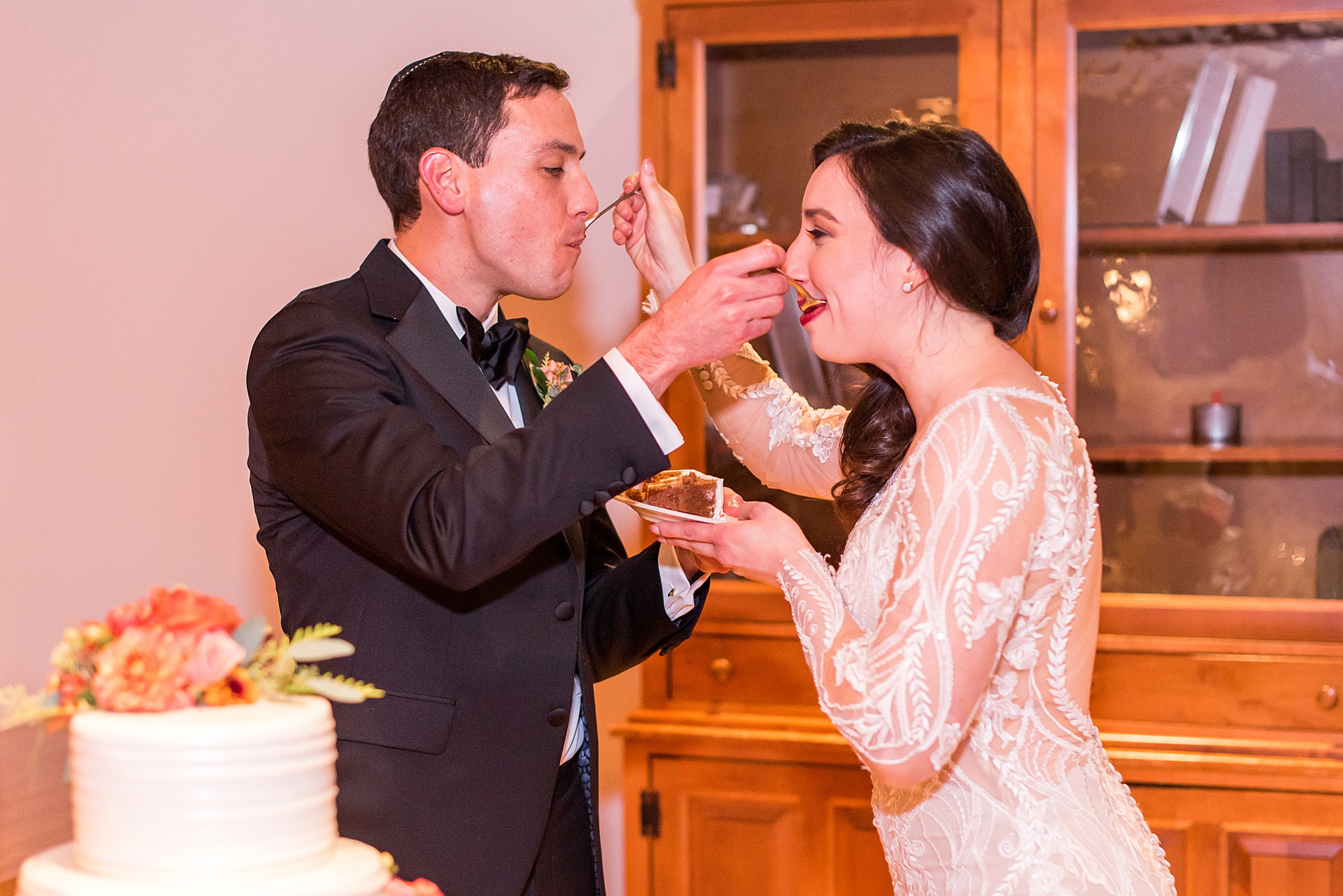 newlyweds feed each other their wedding cake at MA wedding reception at the Warren Conference Center