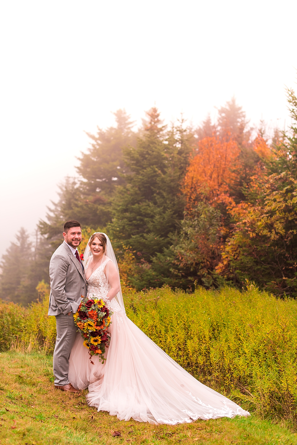 bride and groom at the summit of Mount Sunapee Report with fall foliage in the background