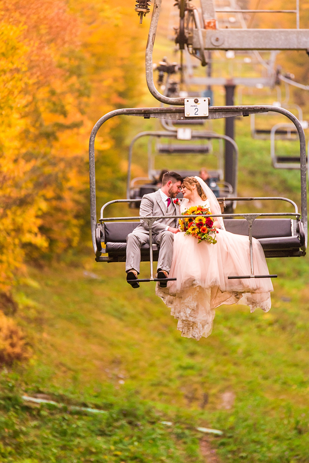 couple on a ski lift coming down from their mountain top wedding at Mount Sunapee in New Hampshire