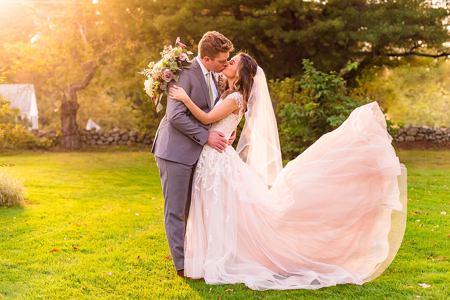 Bride + groom kiss during golden hour at NH Wedding Venue Mile away