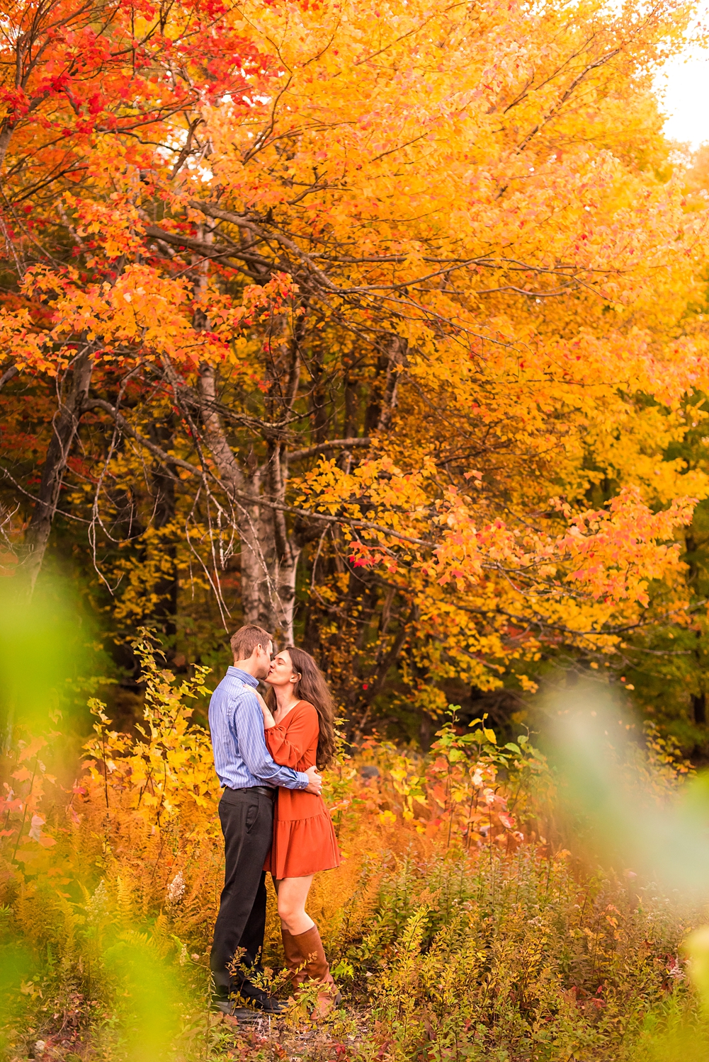 fall engagement photos in NH with colorful leaves in background