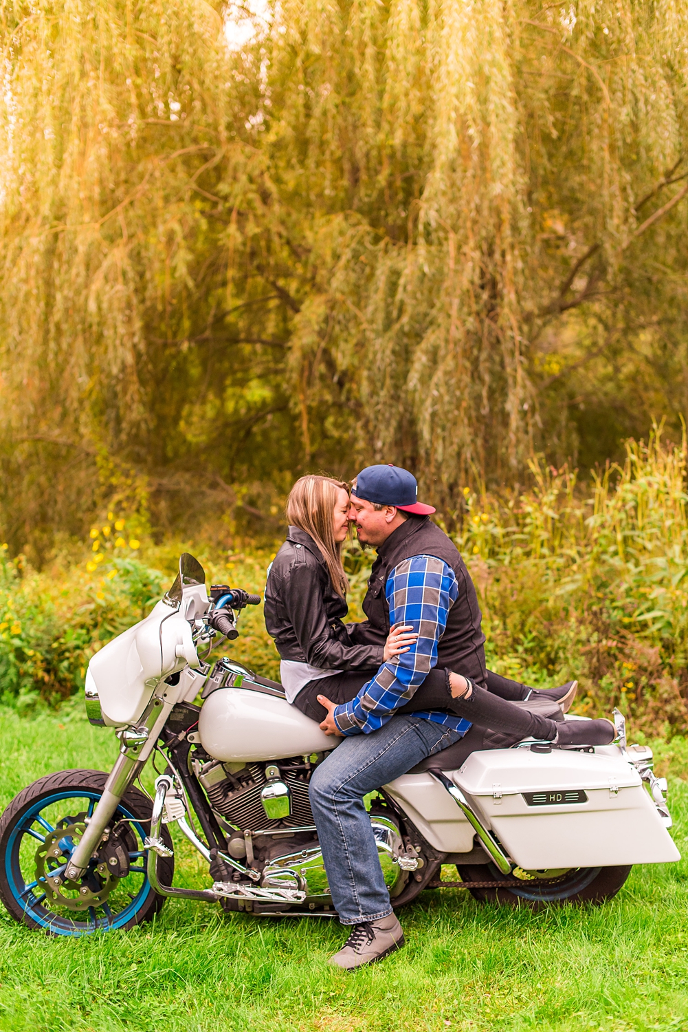 engaged couple kiss on motorcycle