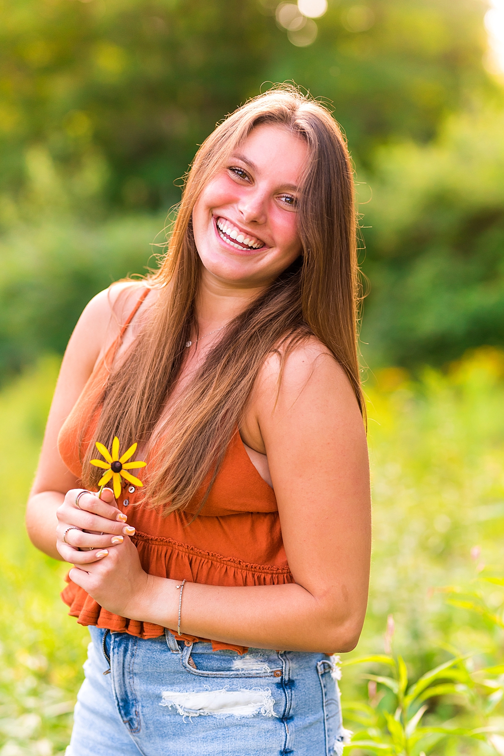 senior girl holding yellow flower during senior session