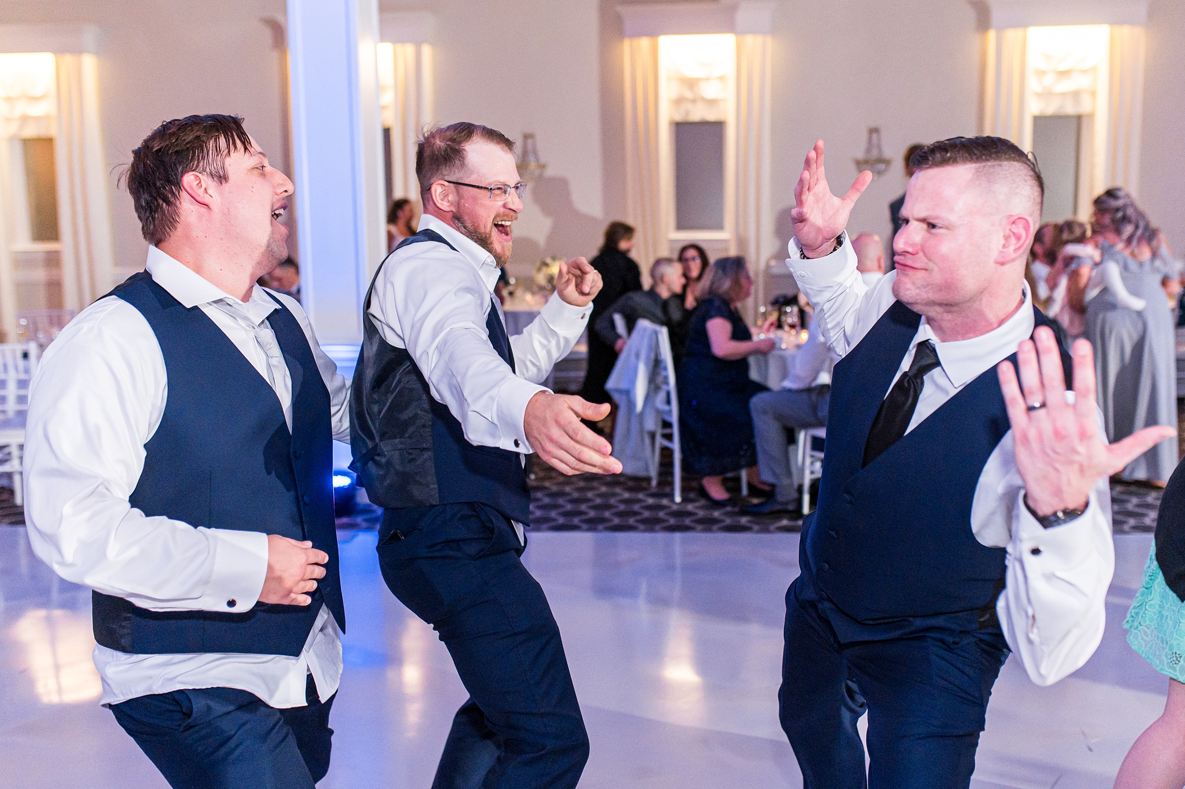 groom and groomsmen have fun dancing