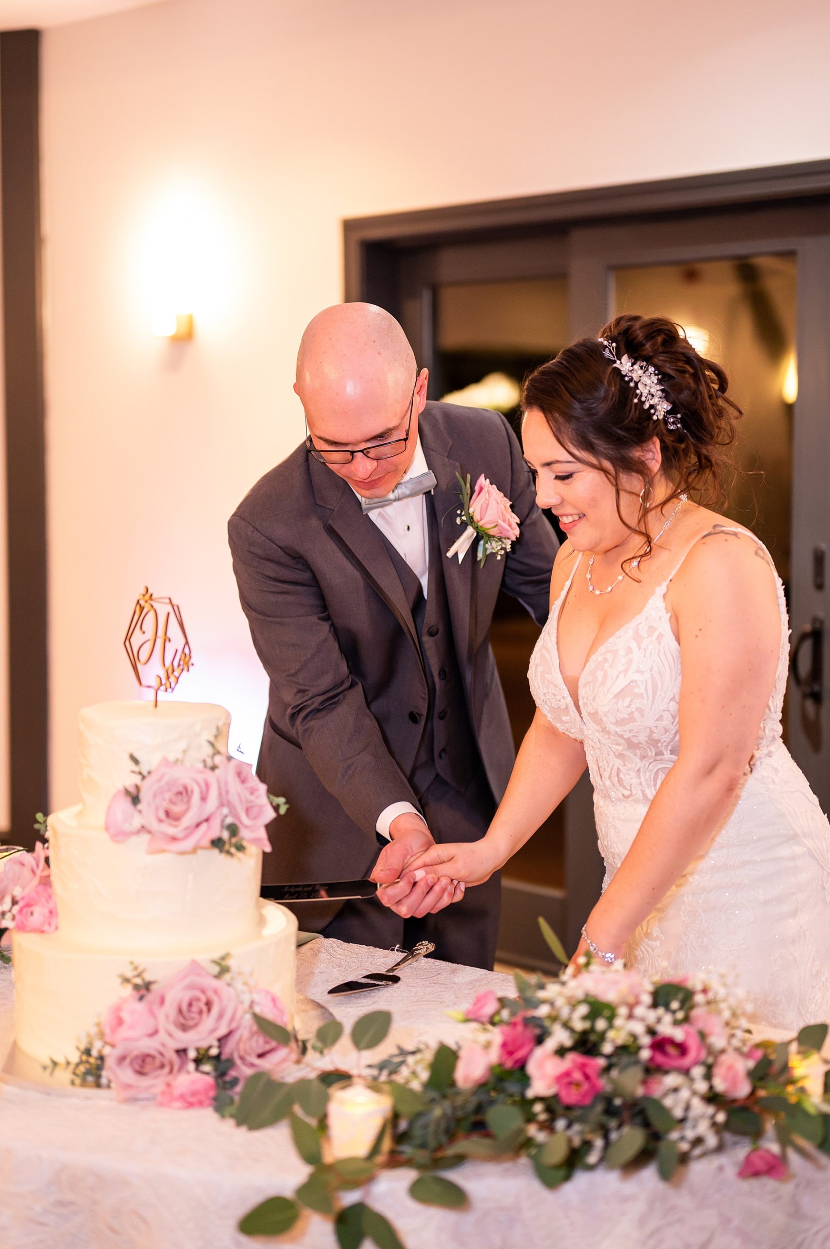couple cut their tiered wedding cake