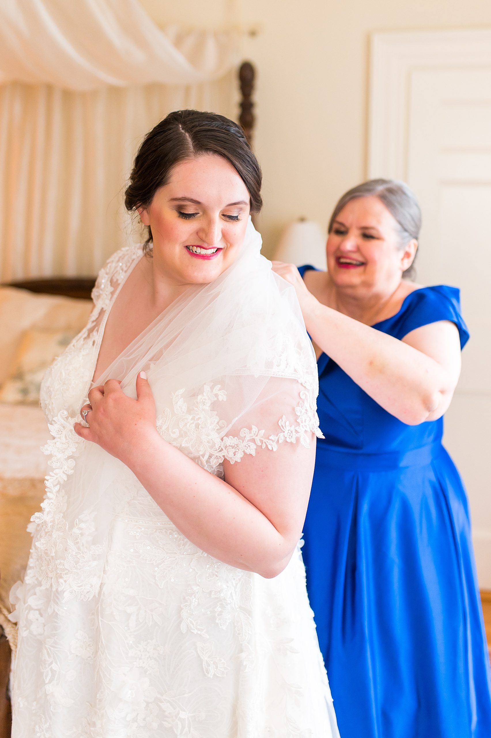 mom helping bride button up wedding dress