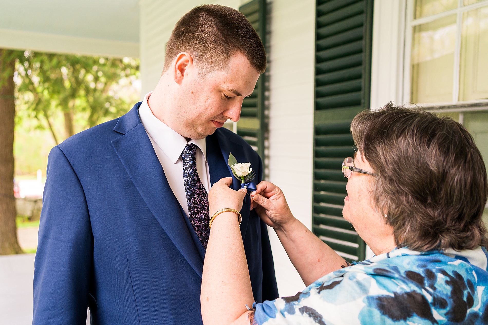 mom helps son with boutonniere before Glen Magna Farms Spring Wedding in Danvers MA