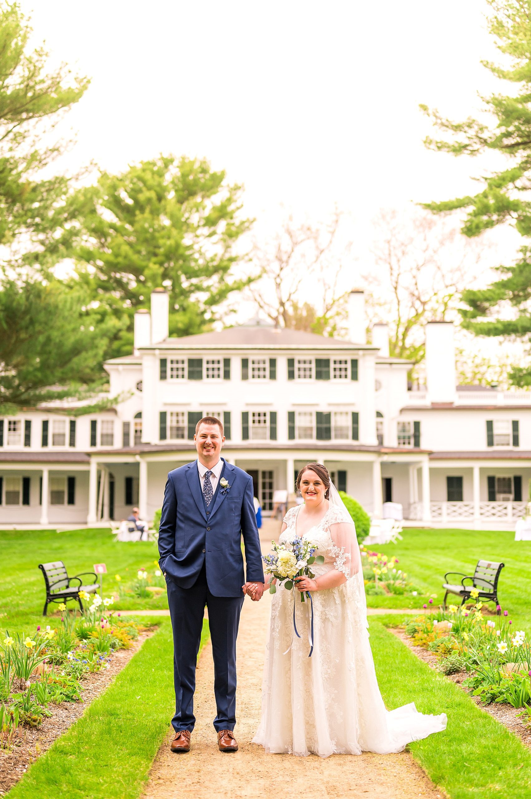 bride and groom stand in front of the classic Glen Magna Farms