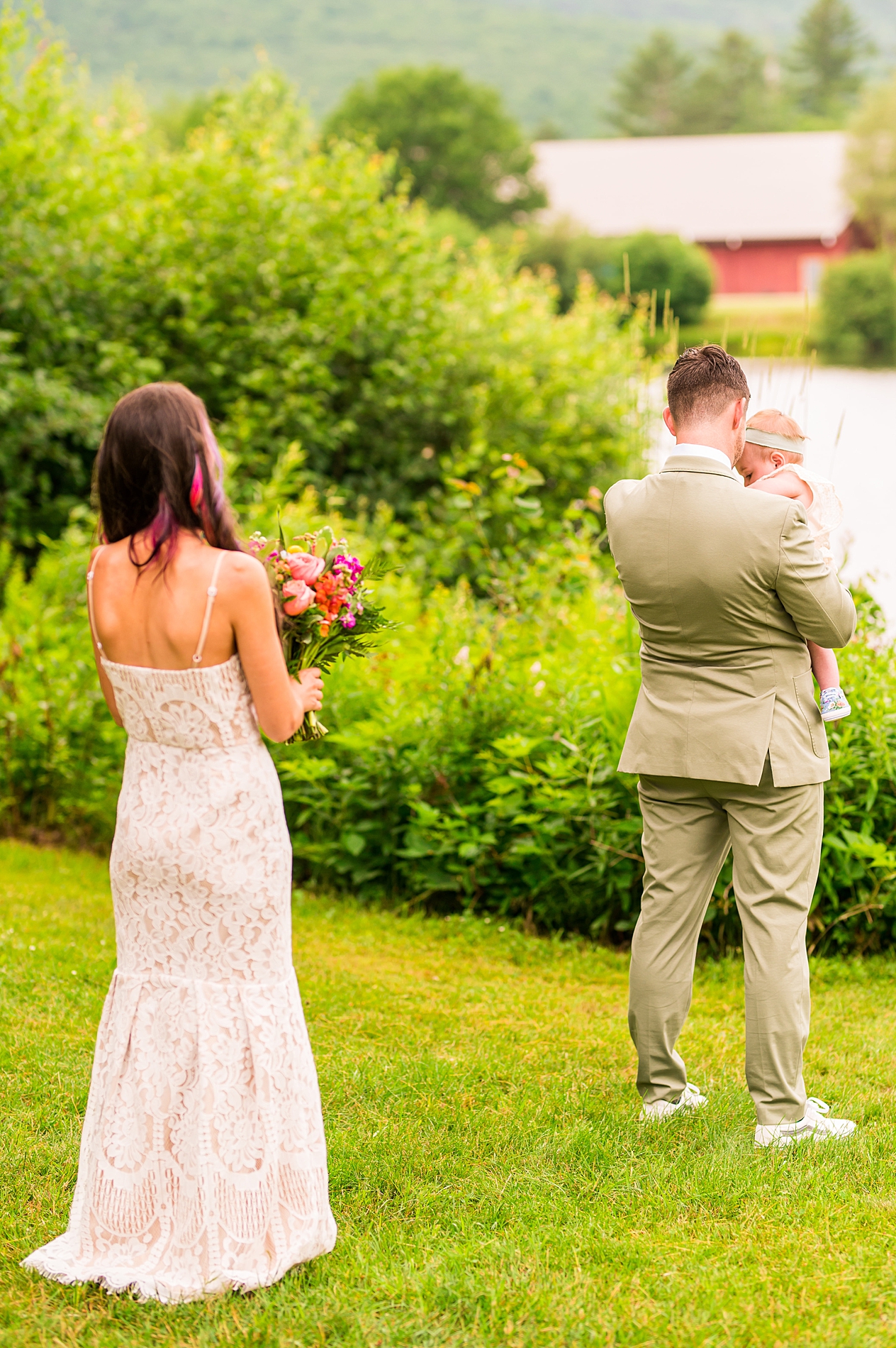 groom holds his daughter as he waits for her mom before their first look 