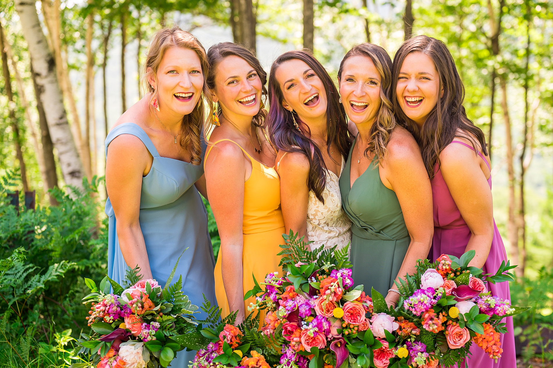 bride with her bridesmaids in bold, deep colored dresses 