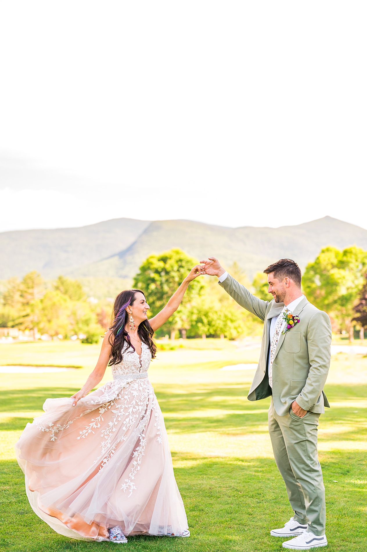 newlyweds dance with the mountains in the background 