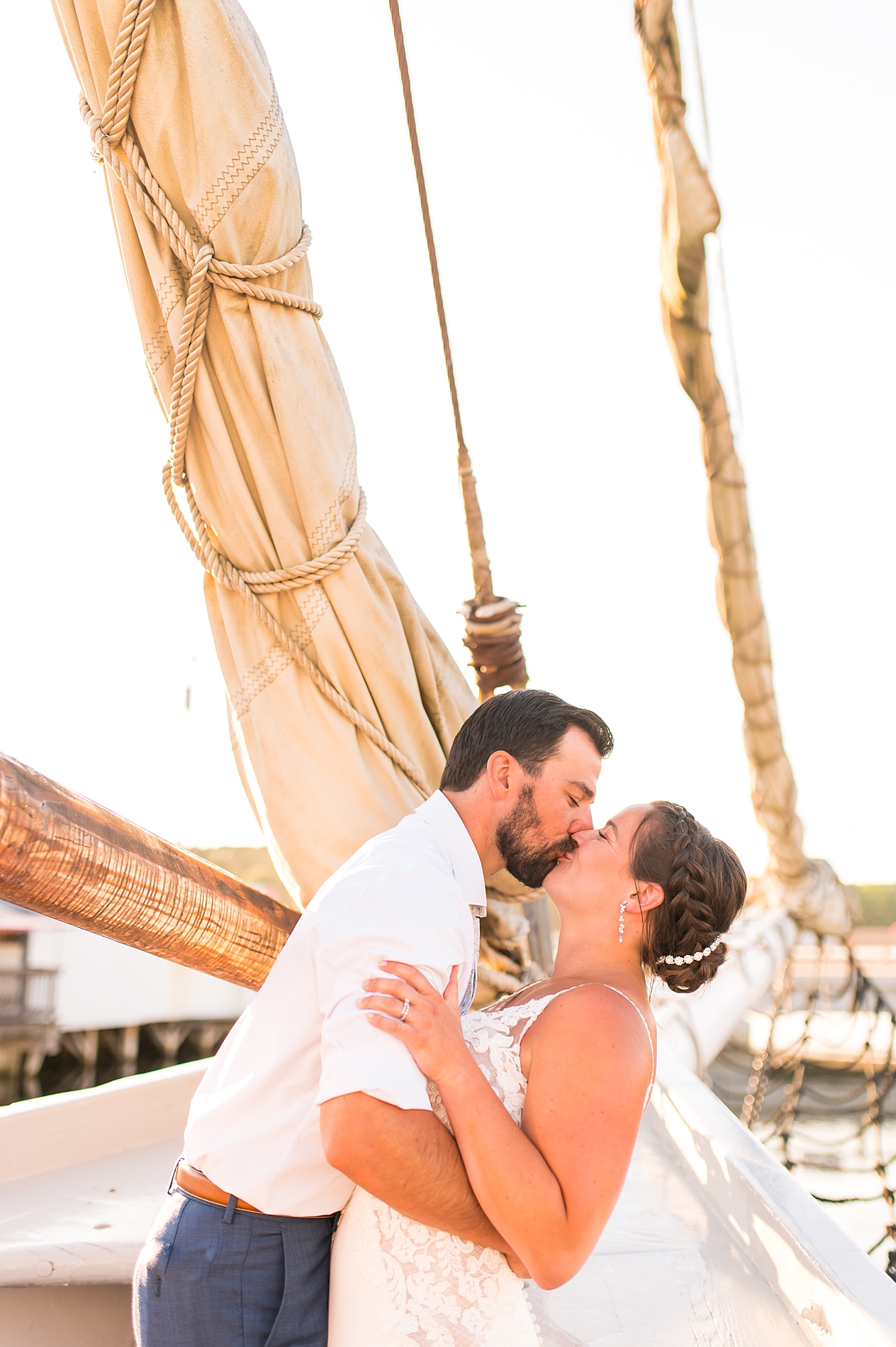 newlyweds kiss on sailboat in Maine