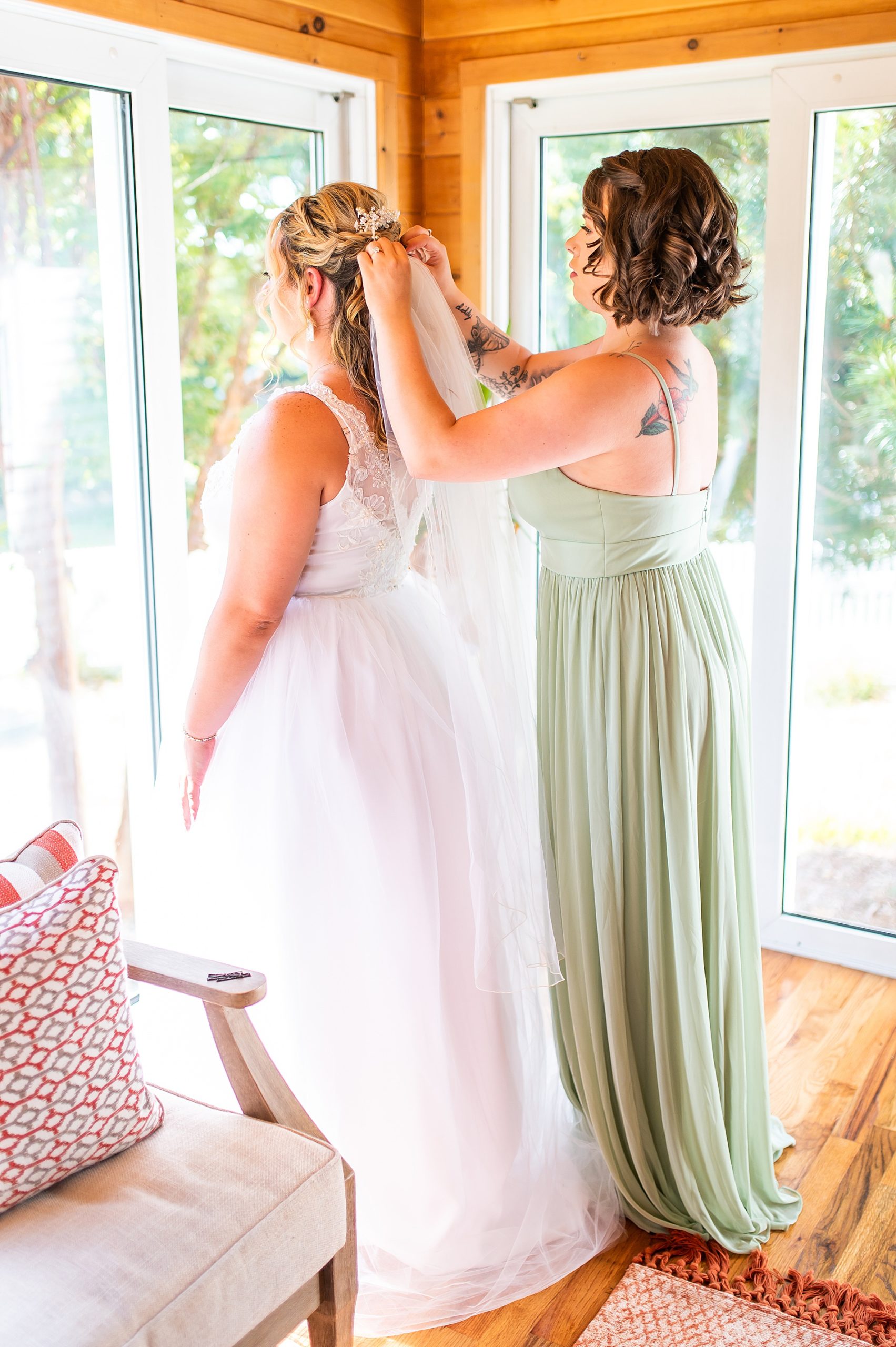 bridesmaid puts hair clip in bride's hair 