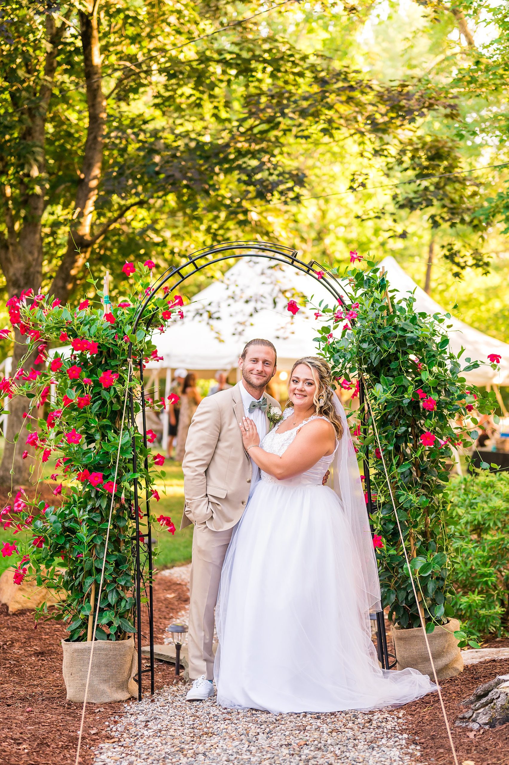 couple in front of flower arch entrance to their outdoor Garden Inspired Connecticut Wedding reception