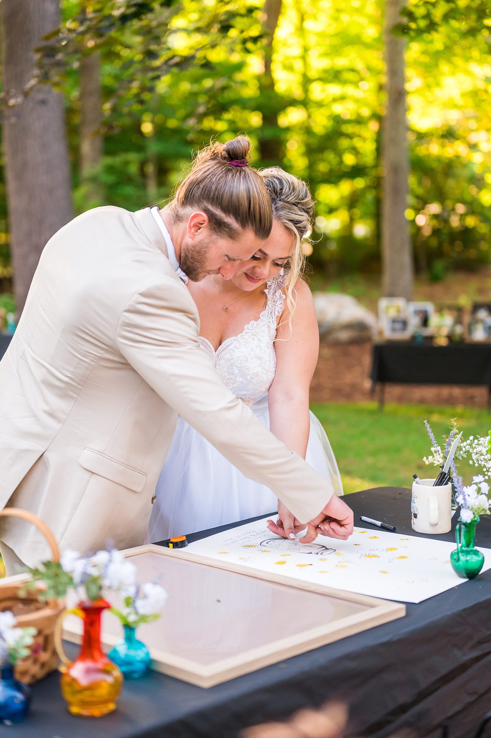 newlyweds place their thumbprint in their guestbook
