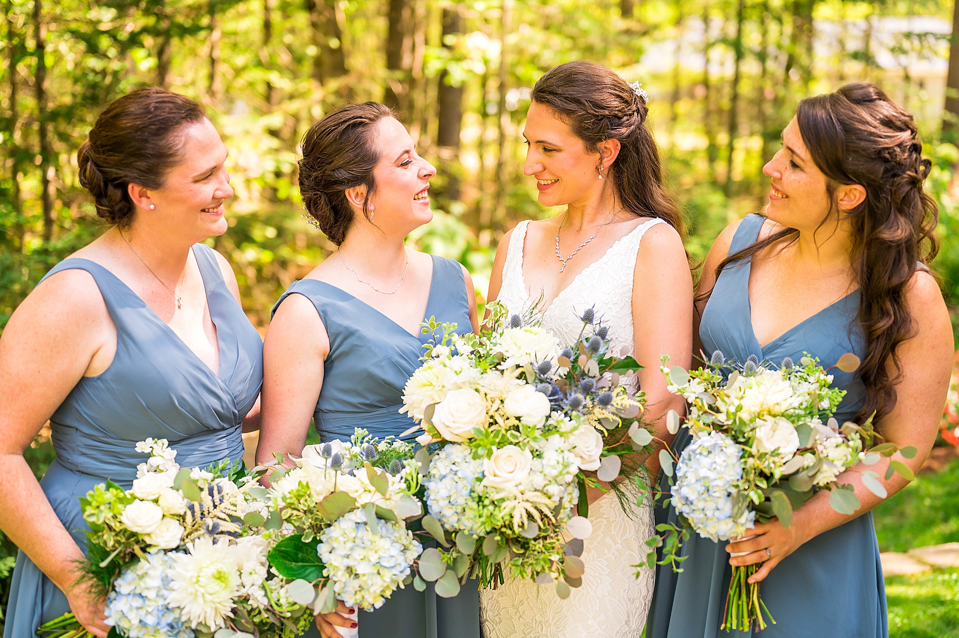 bride and bridesmaids hold wedding bouquets 