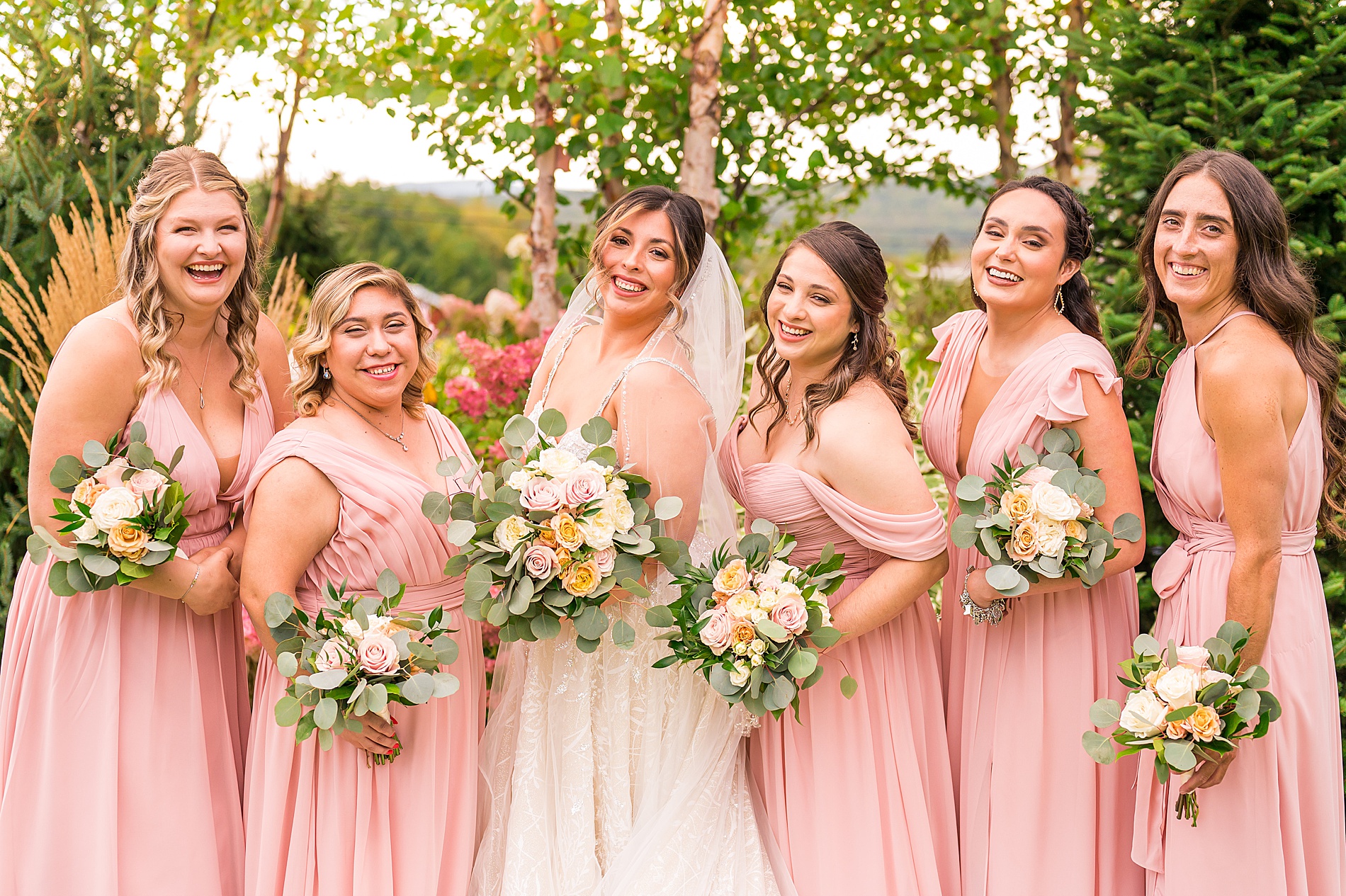 bride and bridesmaids holding summer wedding bouquets 