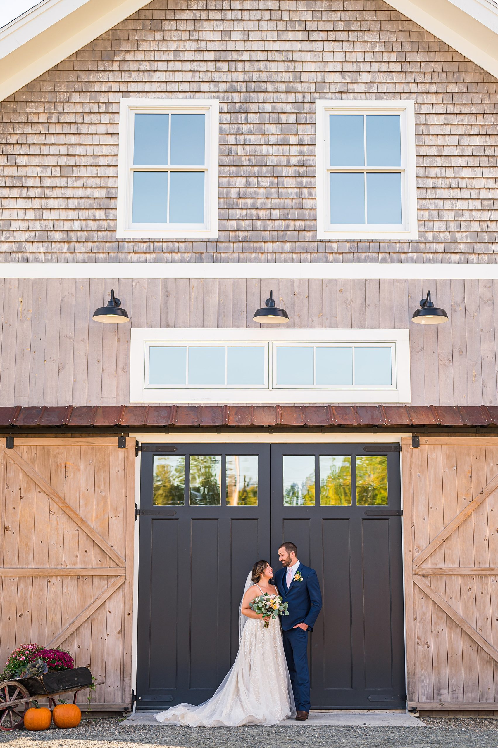 bride and groom outside of rustic barn at Bellevue Barn in NH