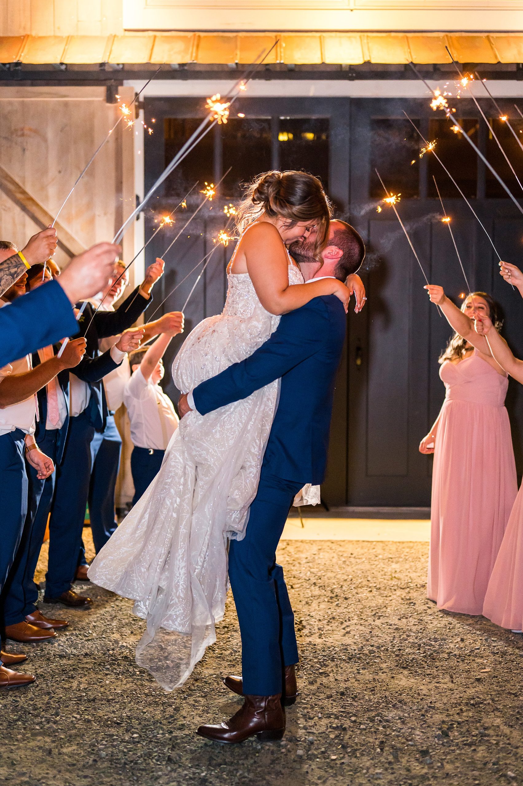newlyweds kiss as they exit reception at Bellevue Barn in New Hampshire