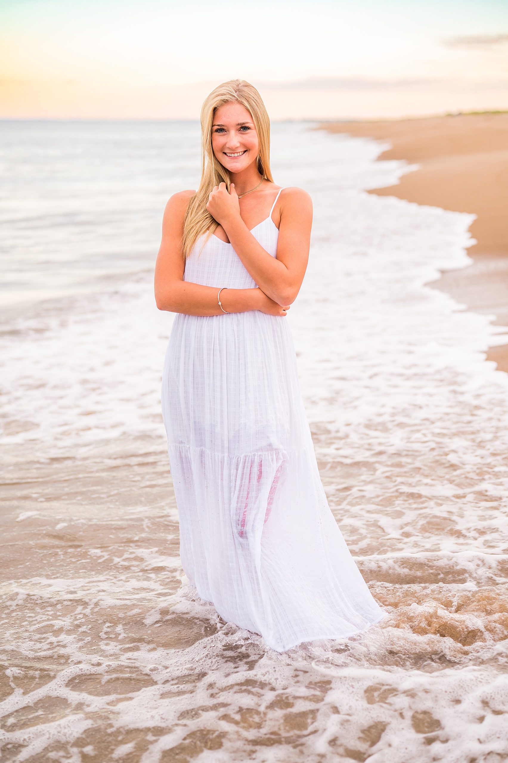 senior girl in white dress on the beach 
