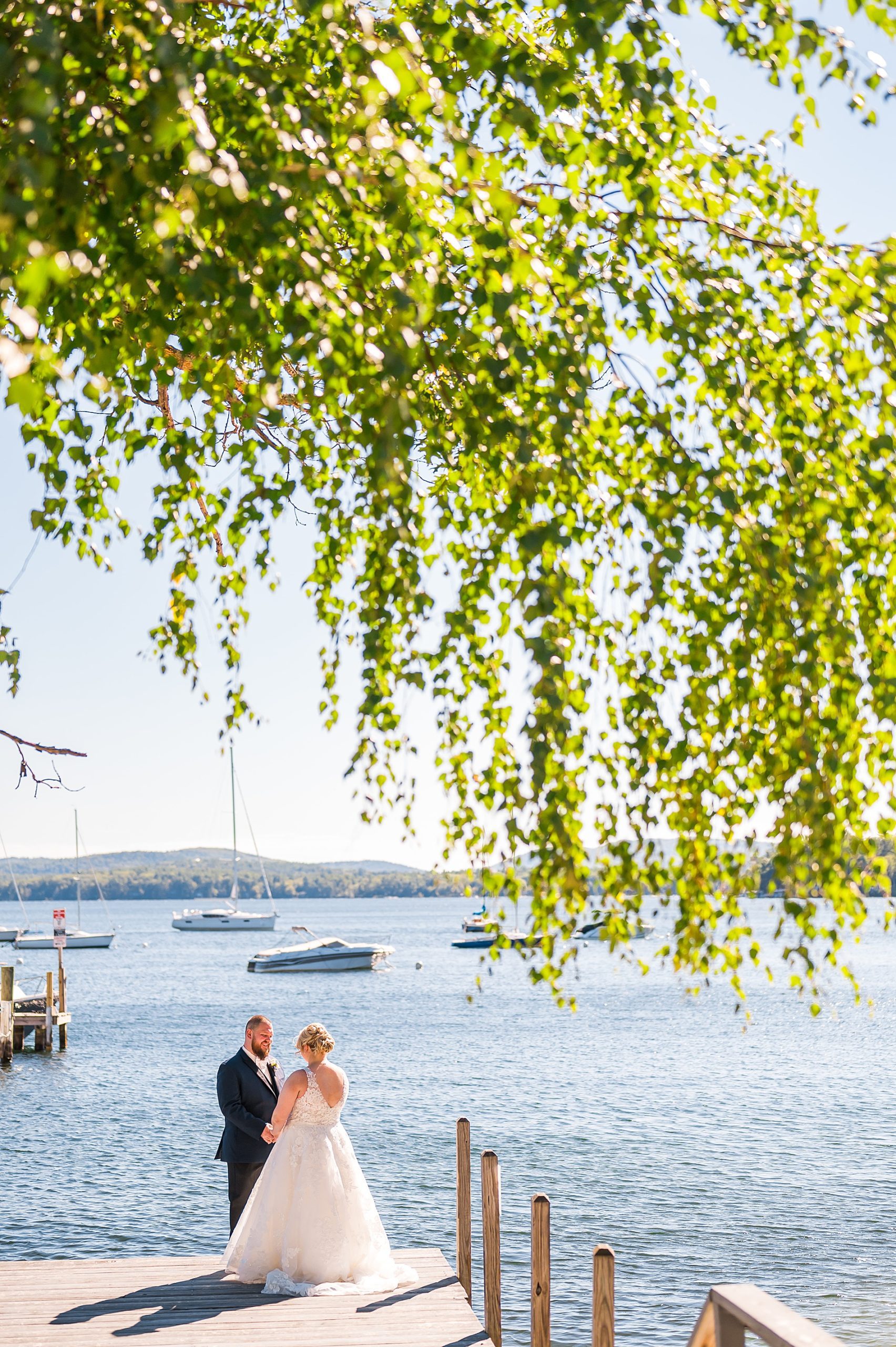 couple share intimate moment down by the water after Wolfeboro Inn Waterfront Wedding