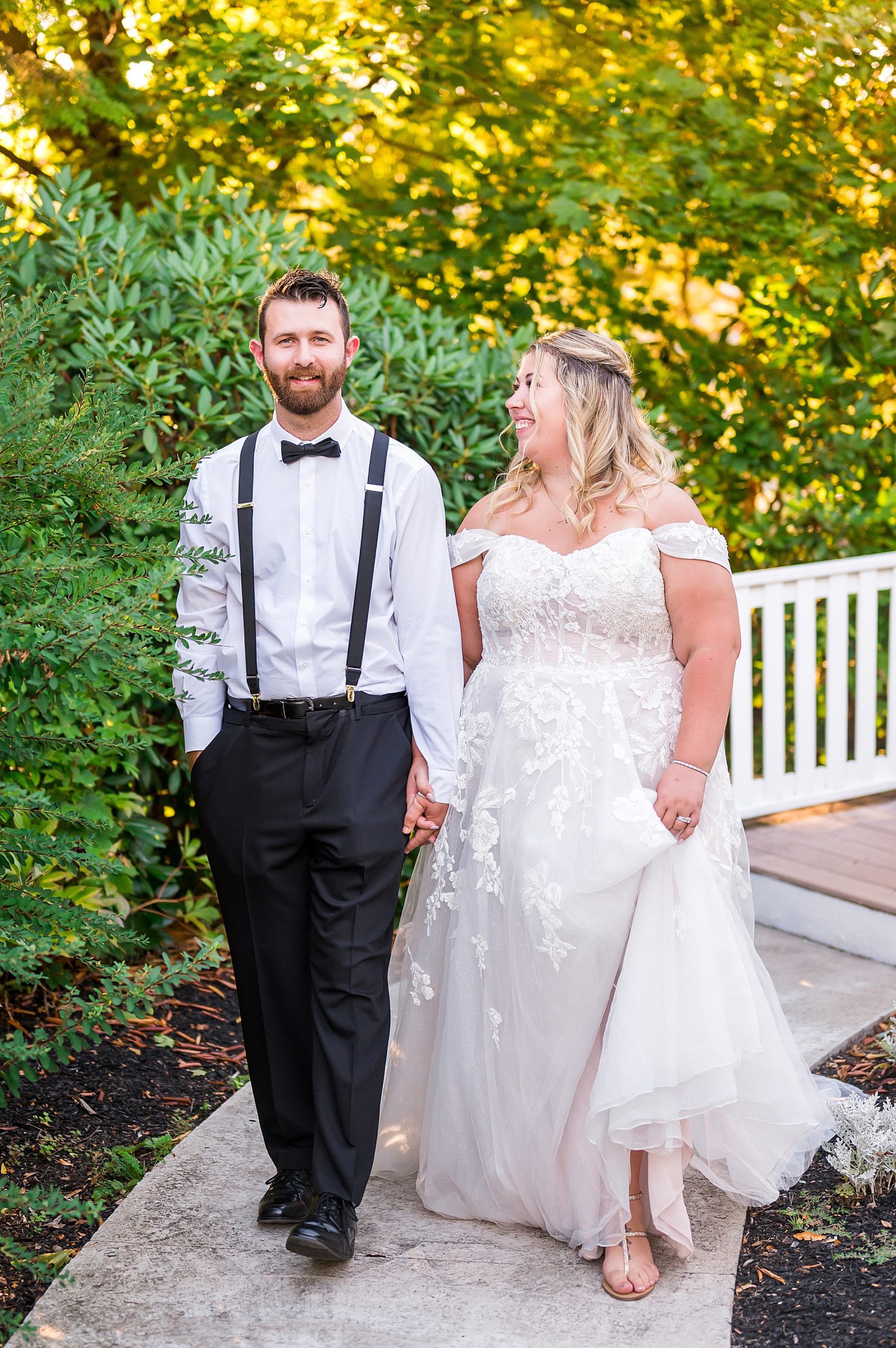 bride + groom walk together holding hands 