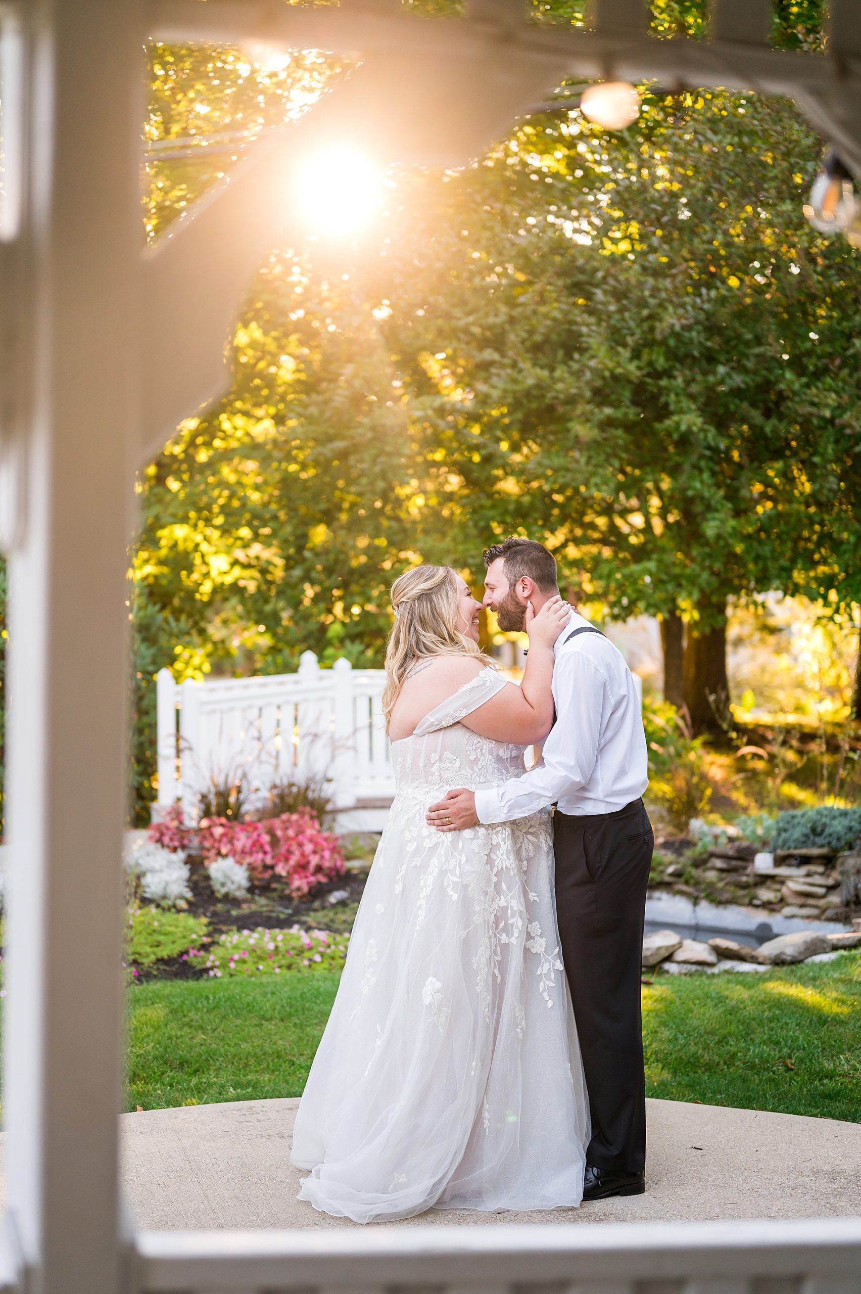 newlyweds kiss with the sun glowing in background 