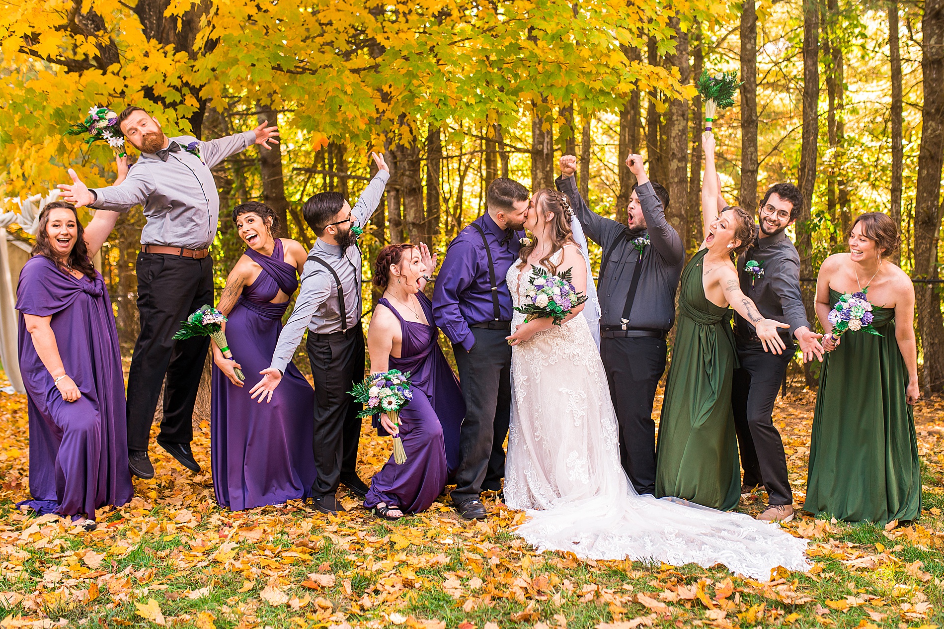 bridal party cheers as bride and groom kiss