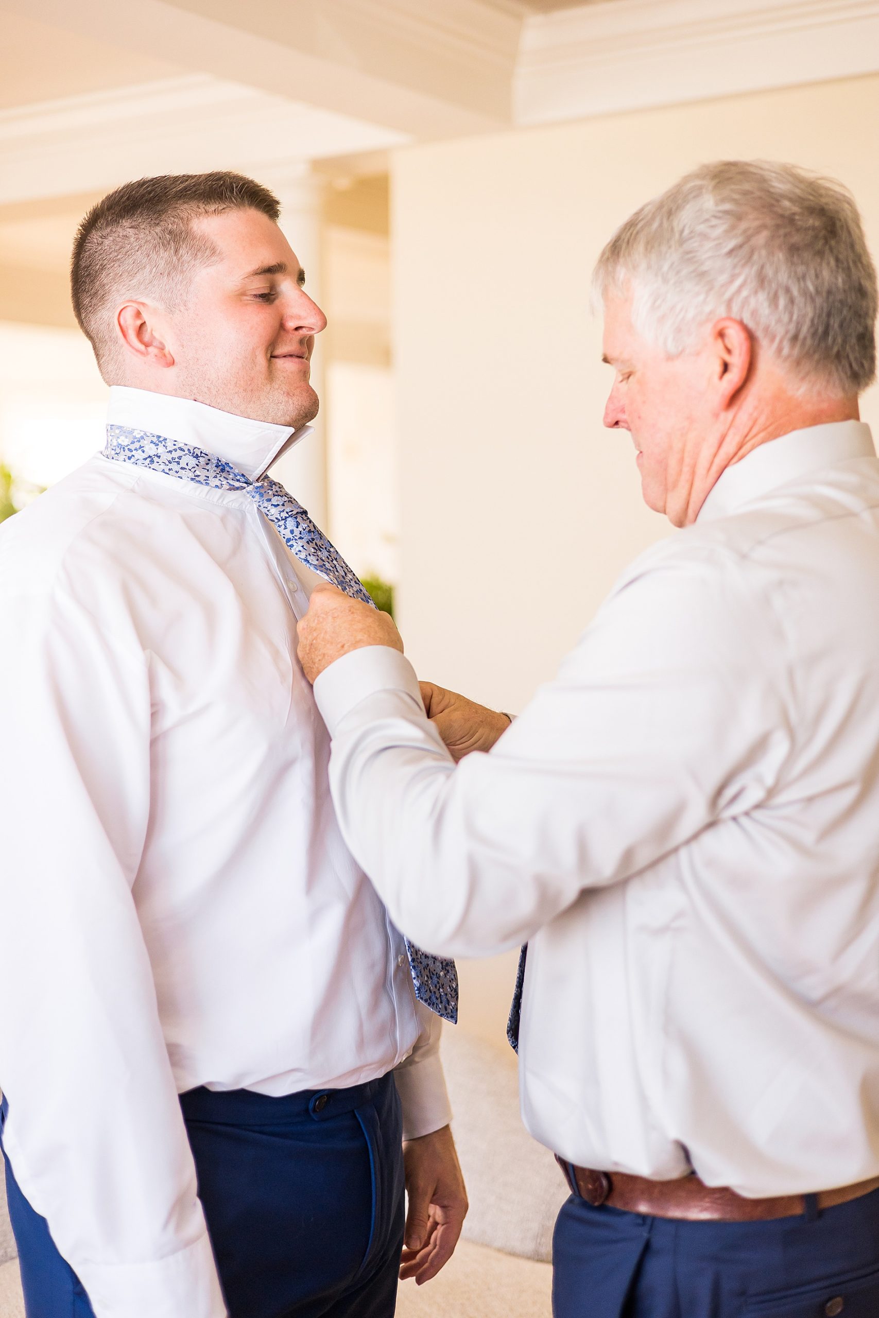 dad helping groom put on his tie