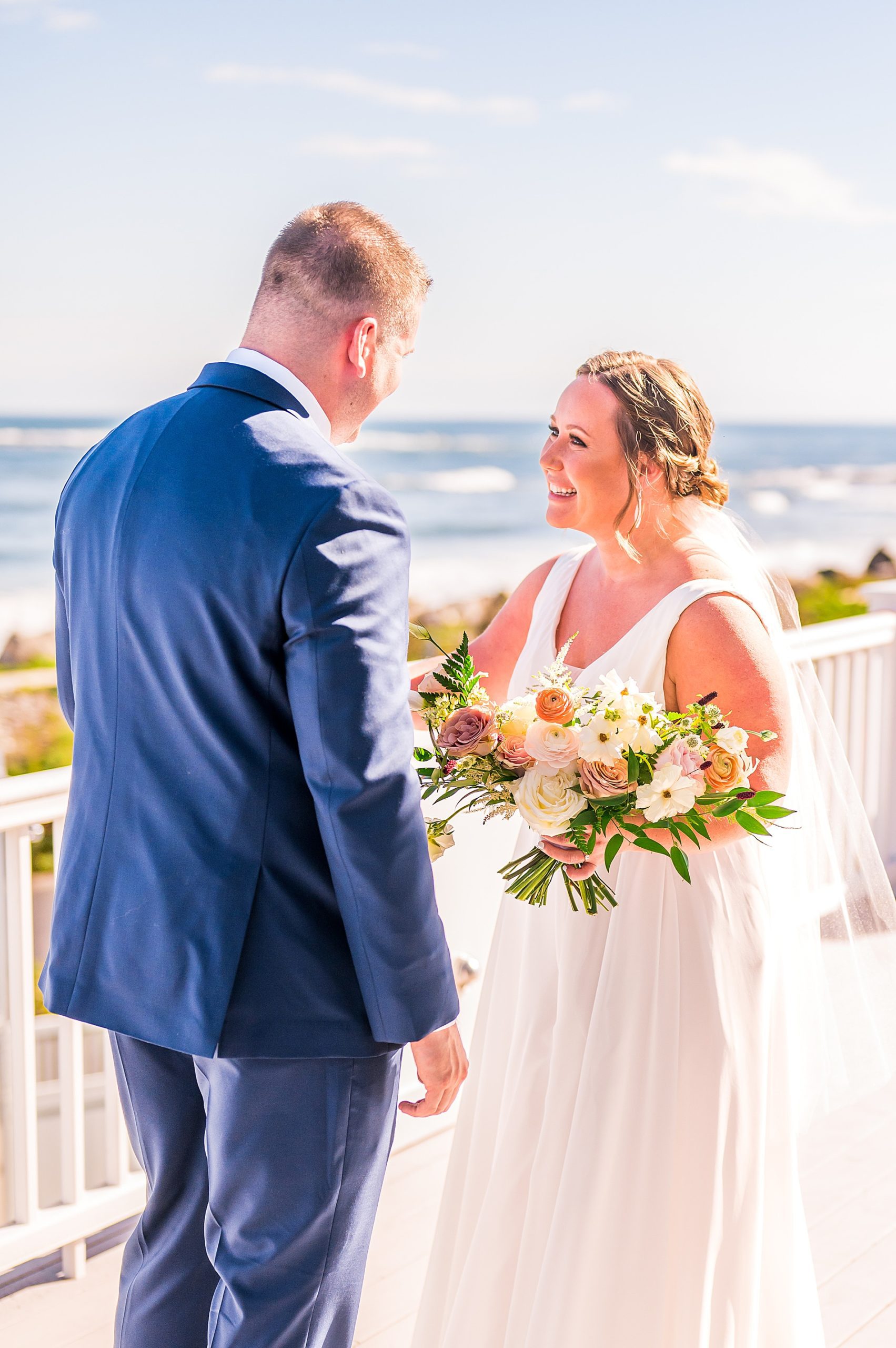 bride and groom during first look on balcony overlooking the ocean