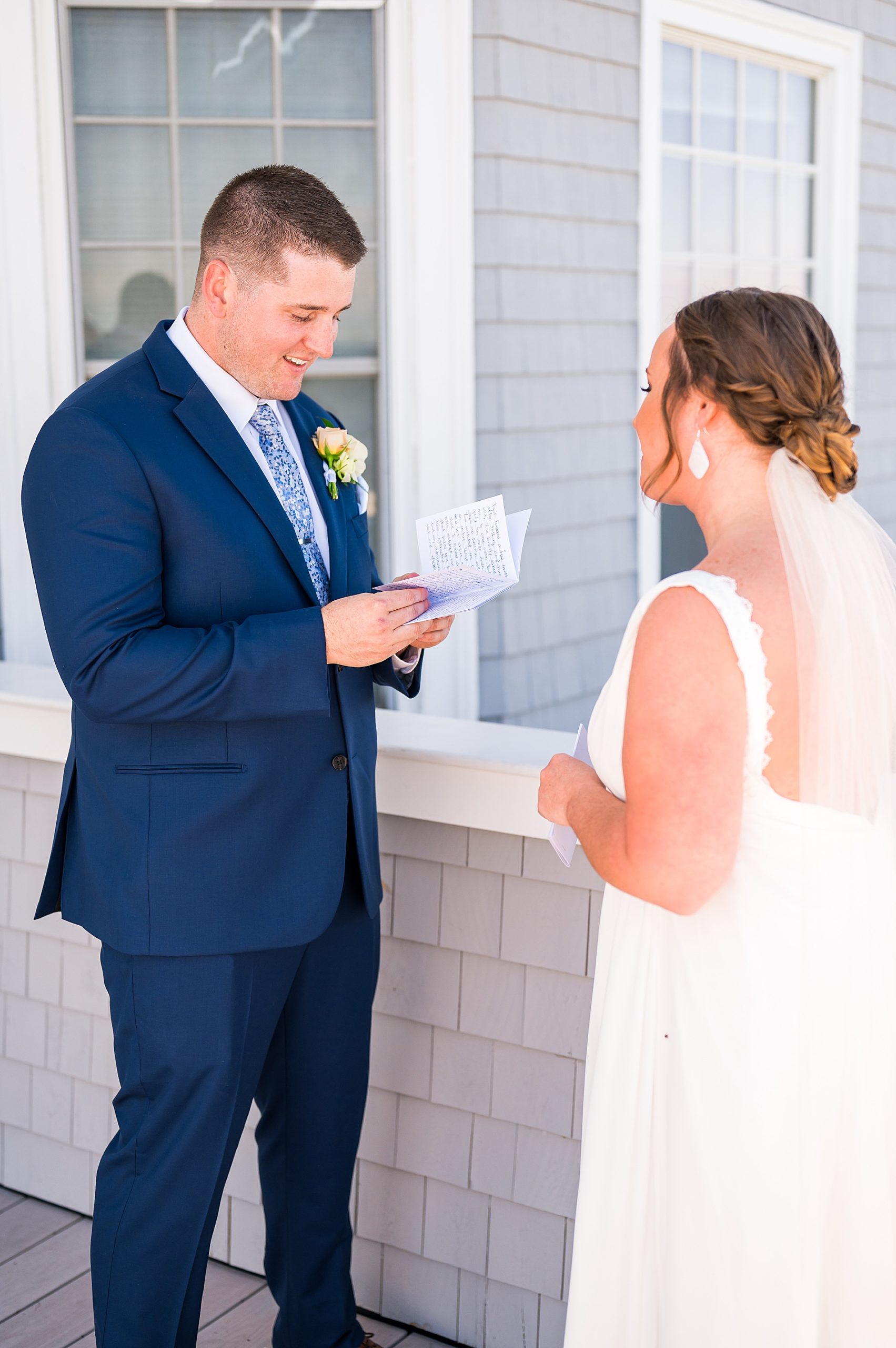 groom reading hand-written vows to bride