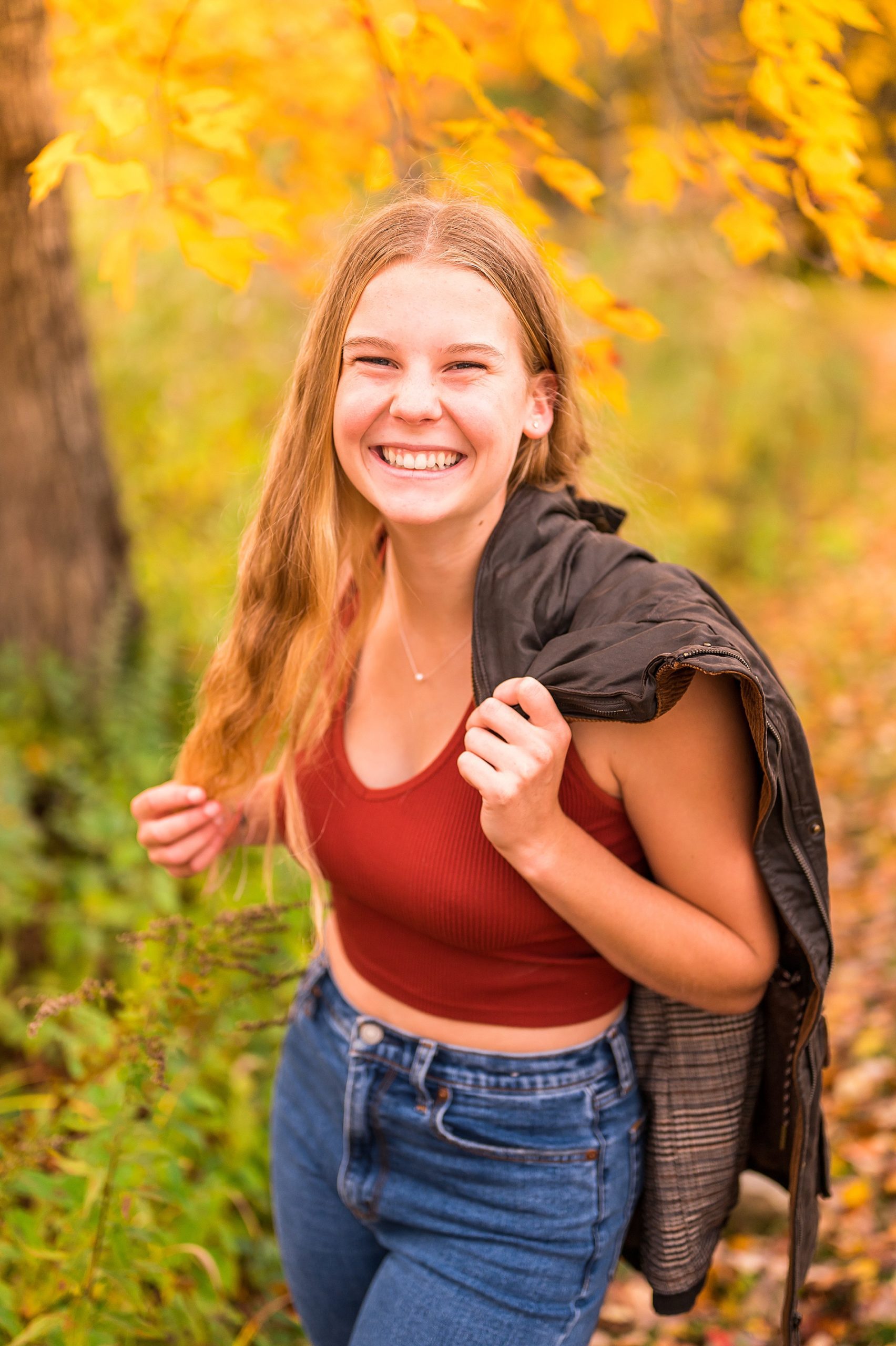 senior walks in the woods with fall scenery all around 