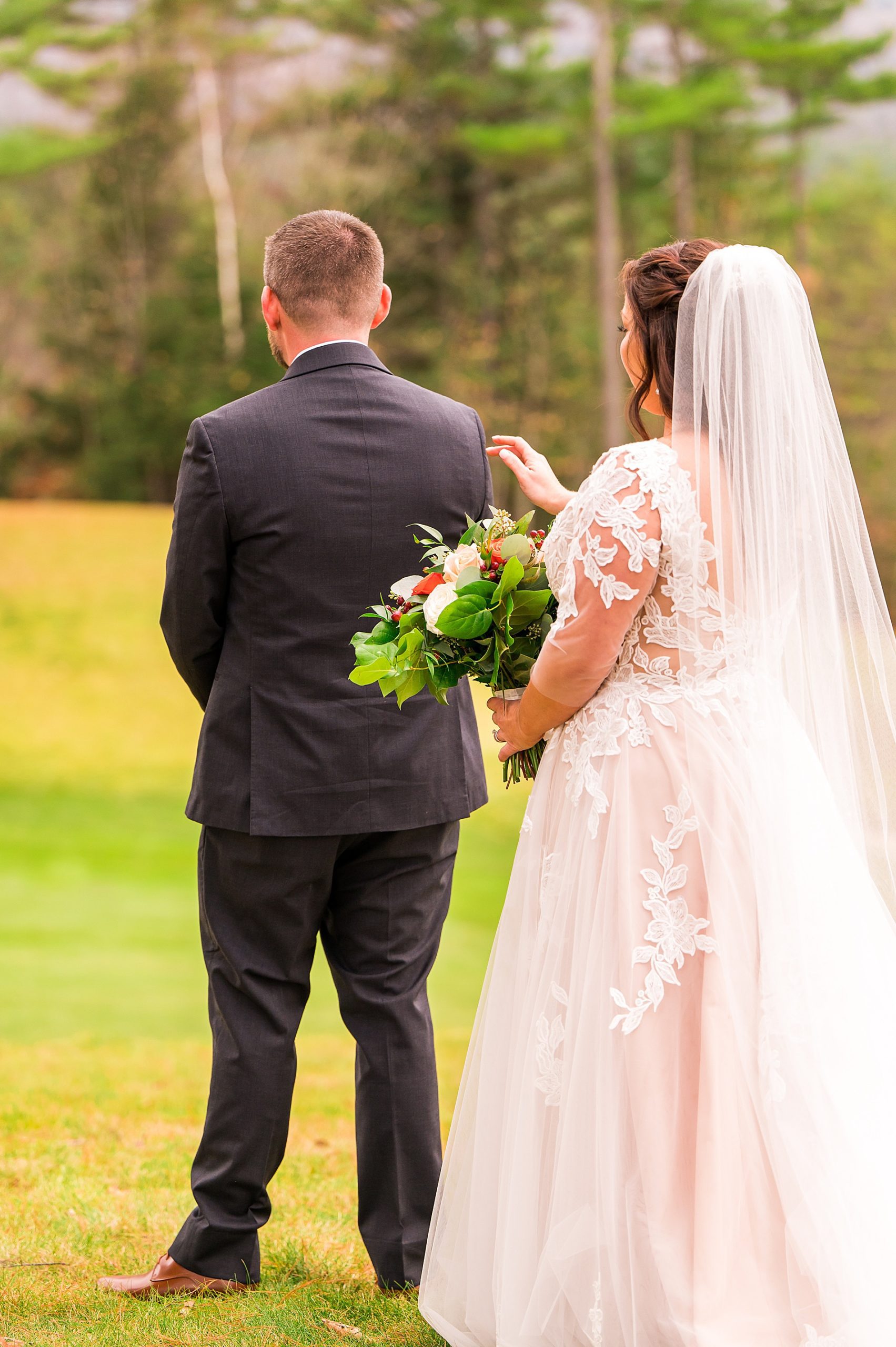 bride taps groom on the back before first look 