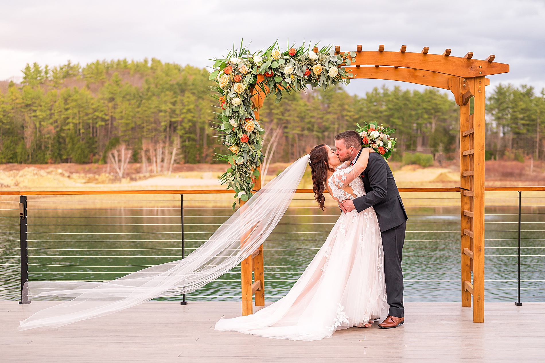 bride and groom kiss with the lake in the background 