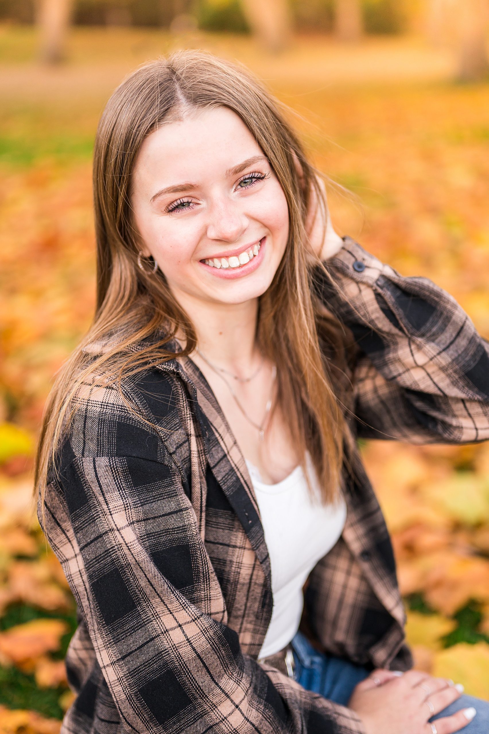 senior in flannel shirt during fall portraits 