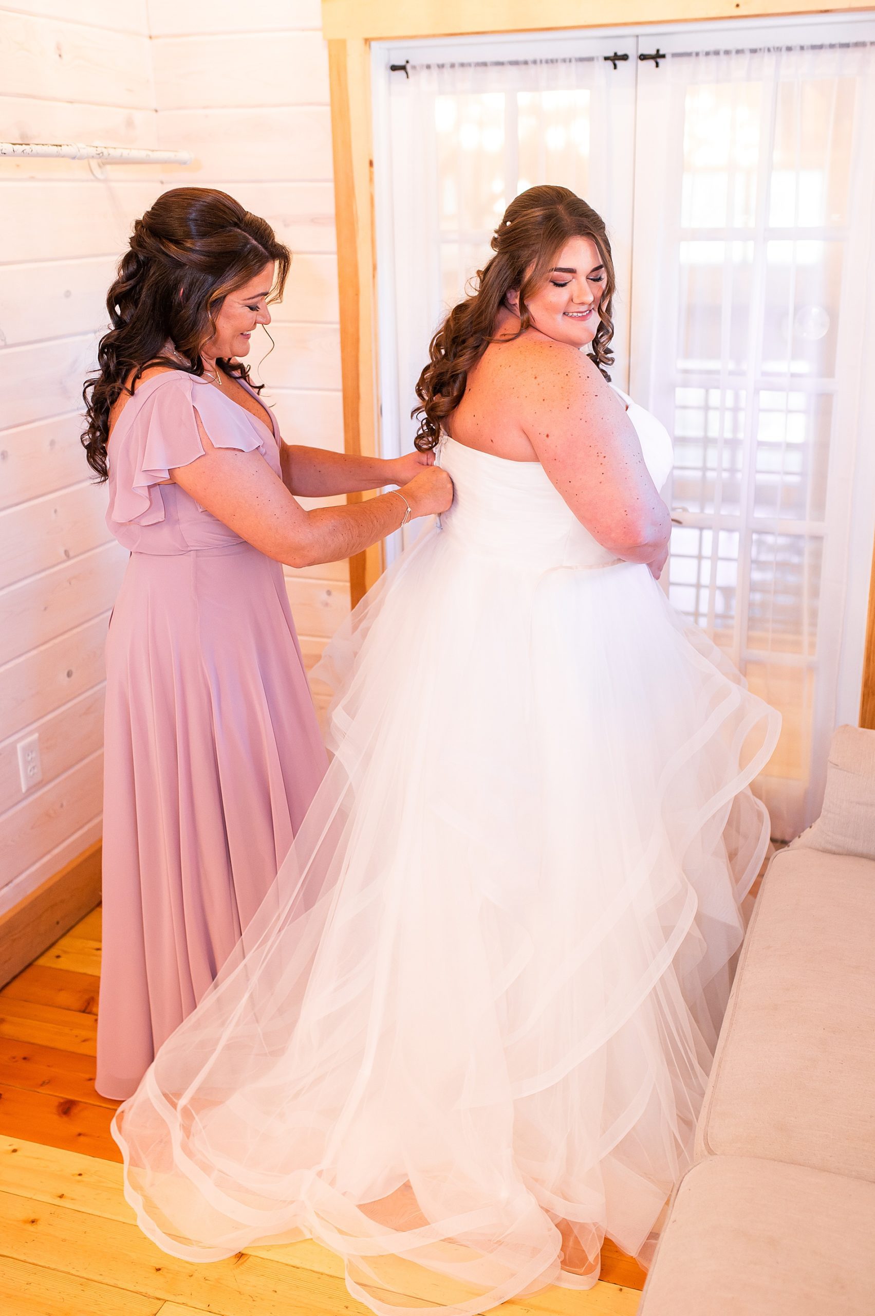 mother helping her daughter into her wedding dress before Concord New Hampshire Wedding 