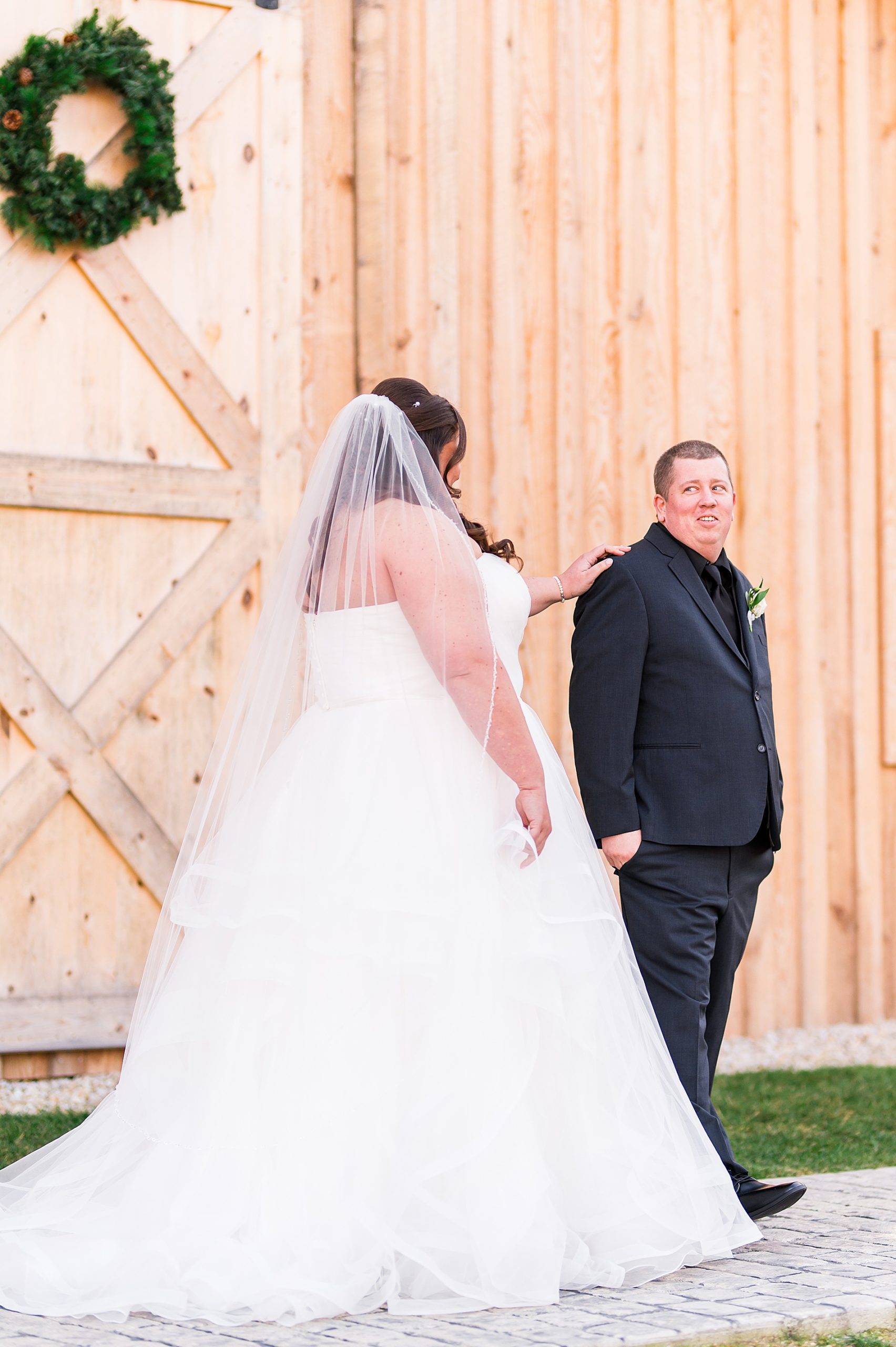 bride taps groom on the shoulder for first look