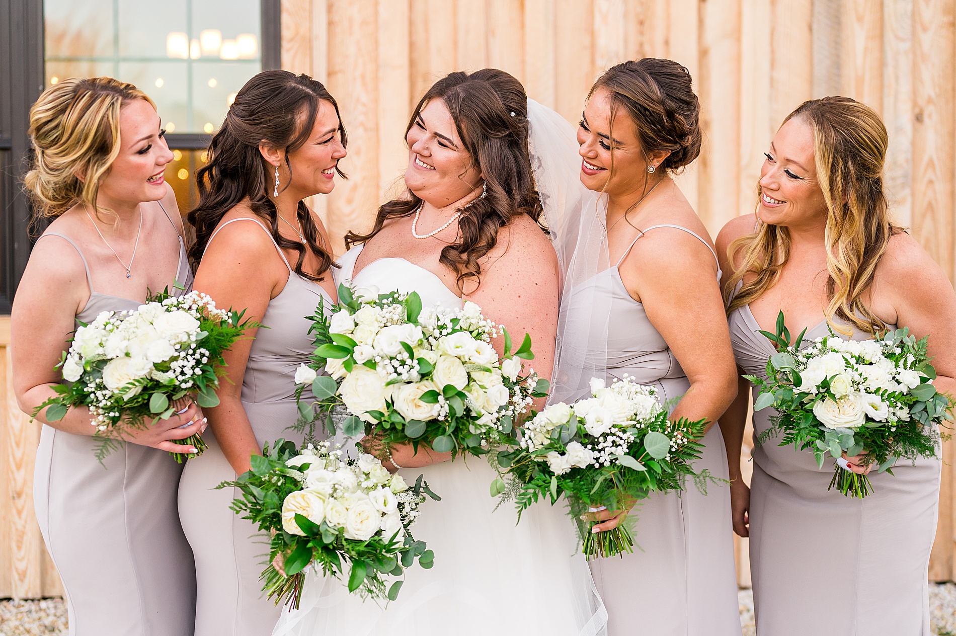 bride and bridesmaids holding white flower bouquets