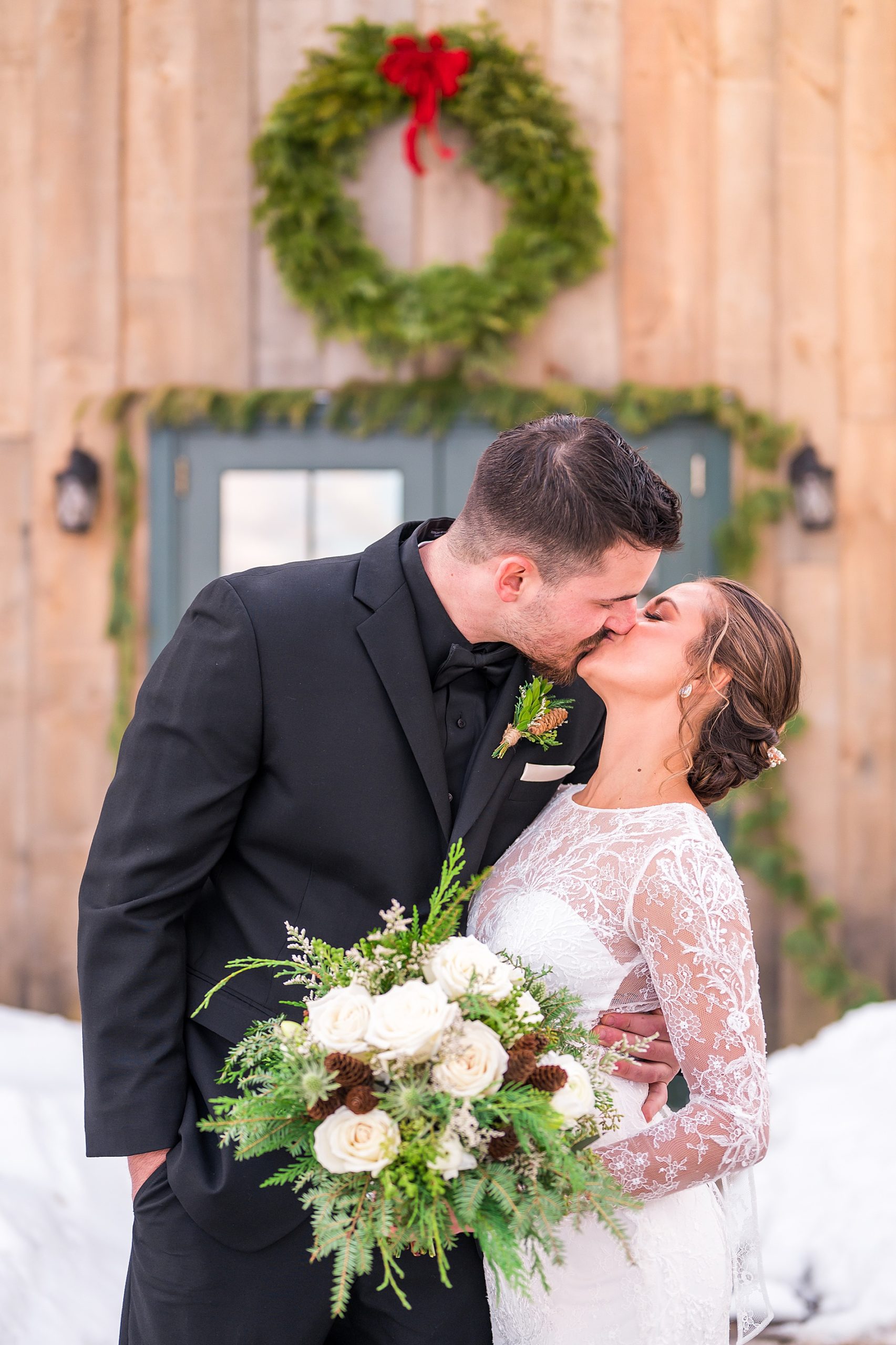 couple kiss outside during winter wedding portraits
