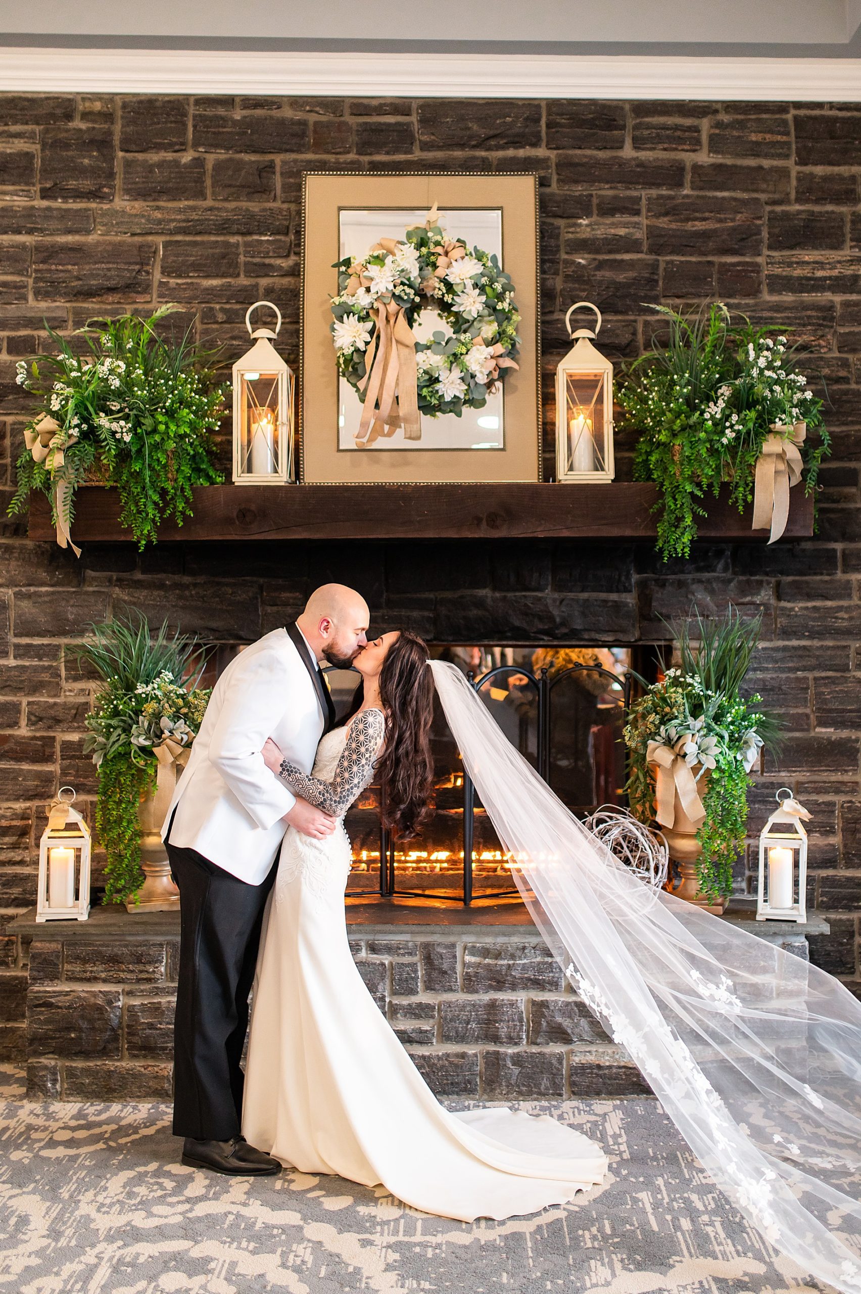 bride and groom kiss by the fireplace at Sky Meadow Country Club