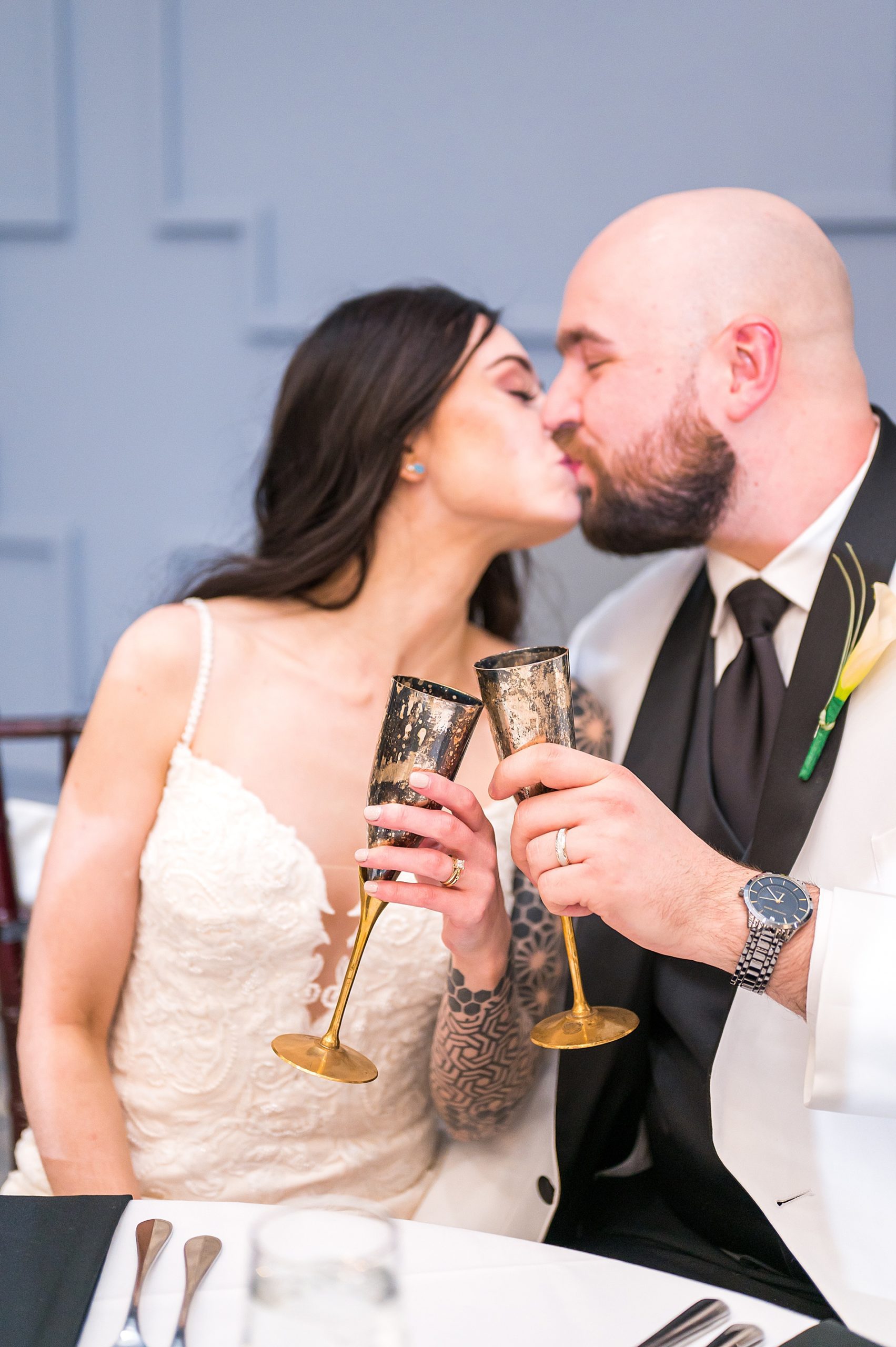 newlyweds kiss holding their champagne glasses