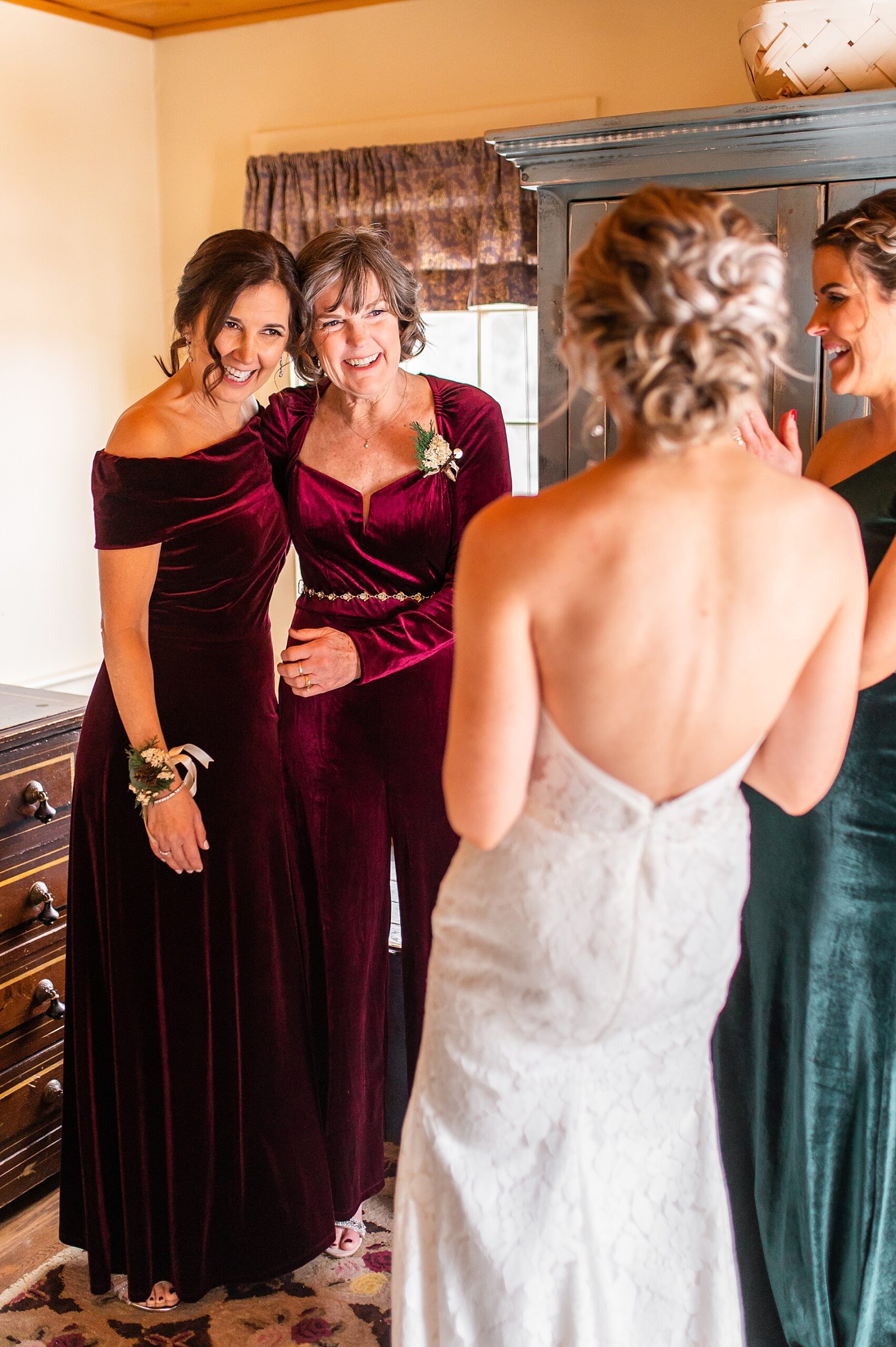 bride getting ready with bridesmaids, mother, and sister