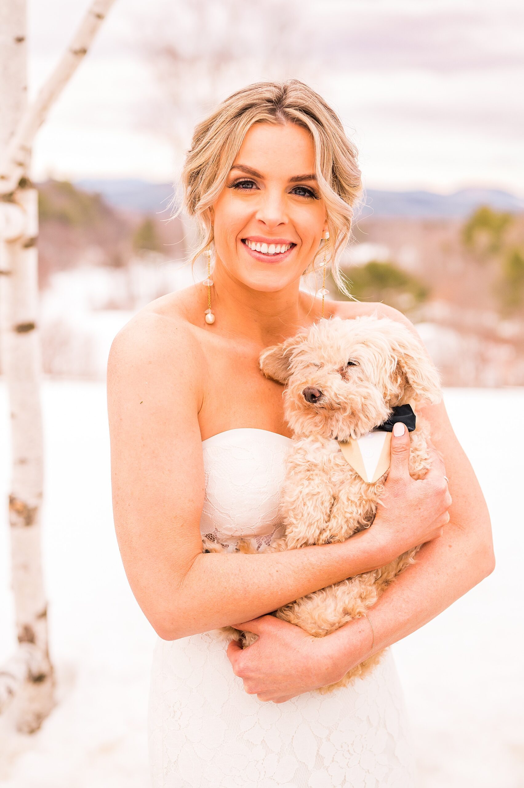 bride holding her dog outside at The Barn on the Pemi