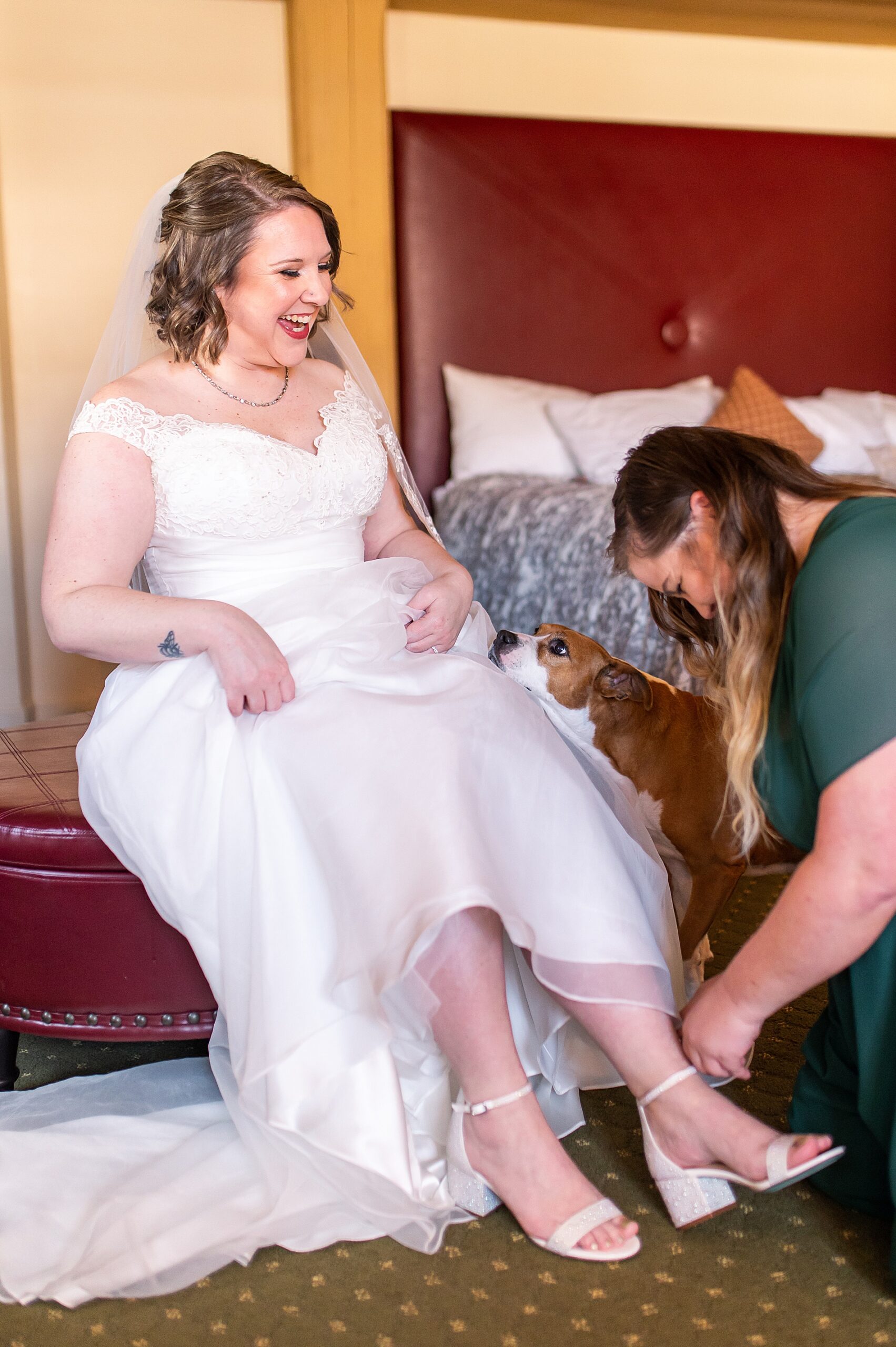 bridesmaid helps bride with shoes