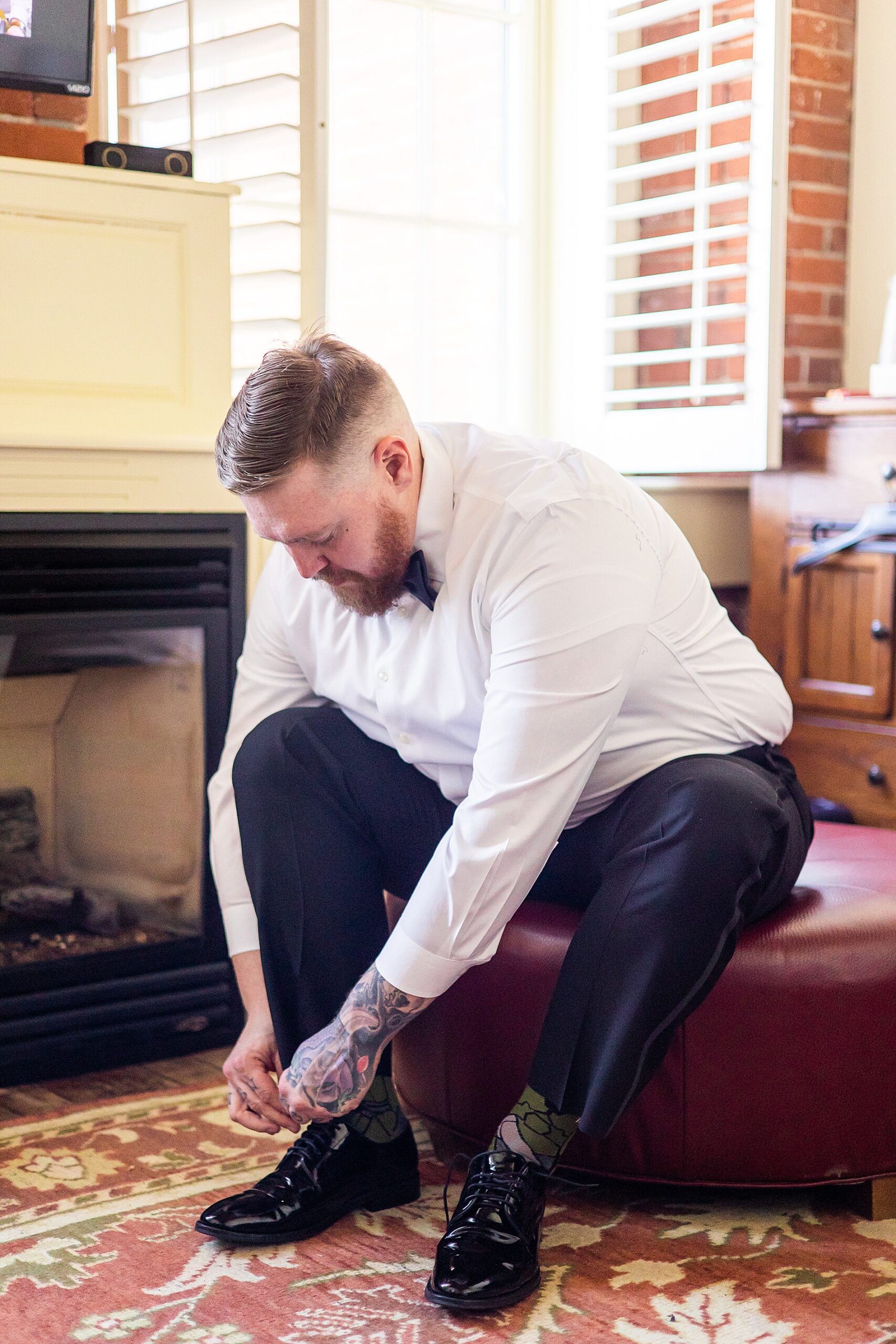 groom putting on shoes before Claremont New Hampshire Wedding 