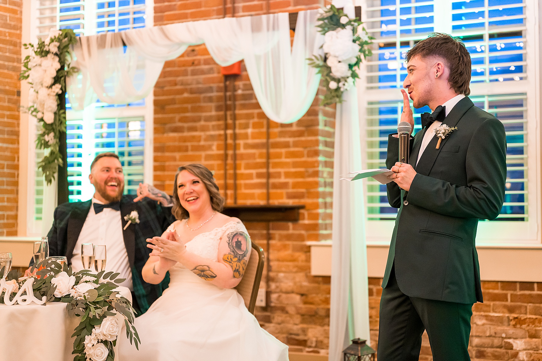 newlyweds laugh during wedding toasts