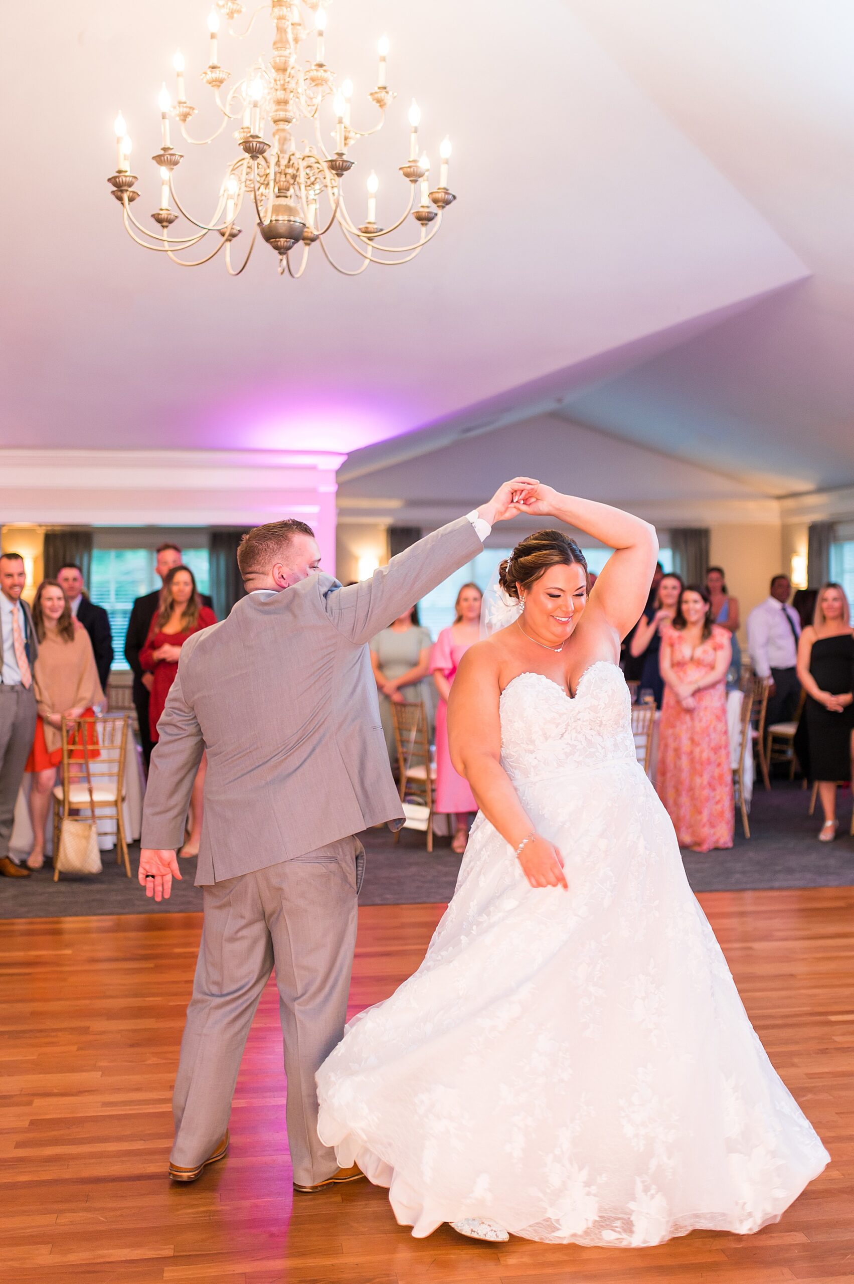 groom twirls bride on dance floor
