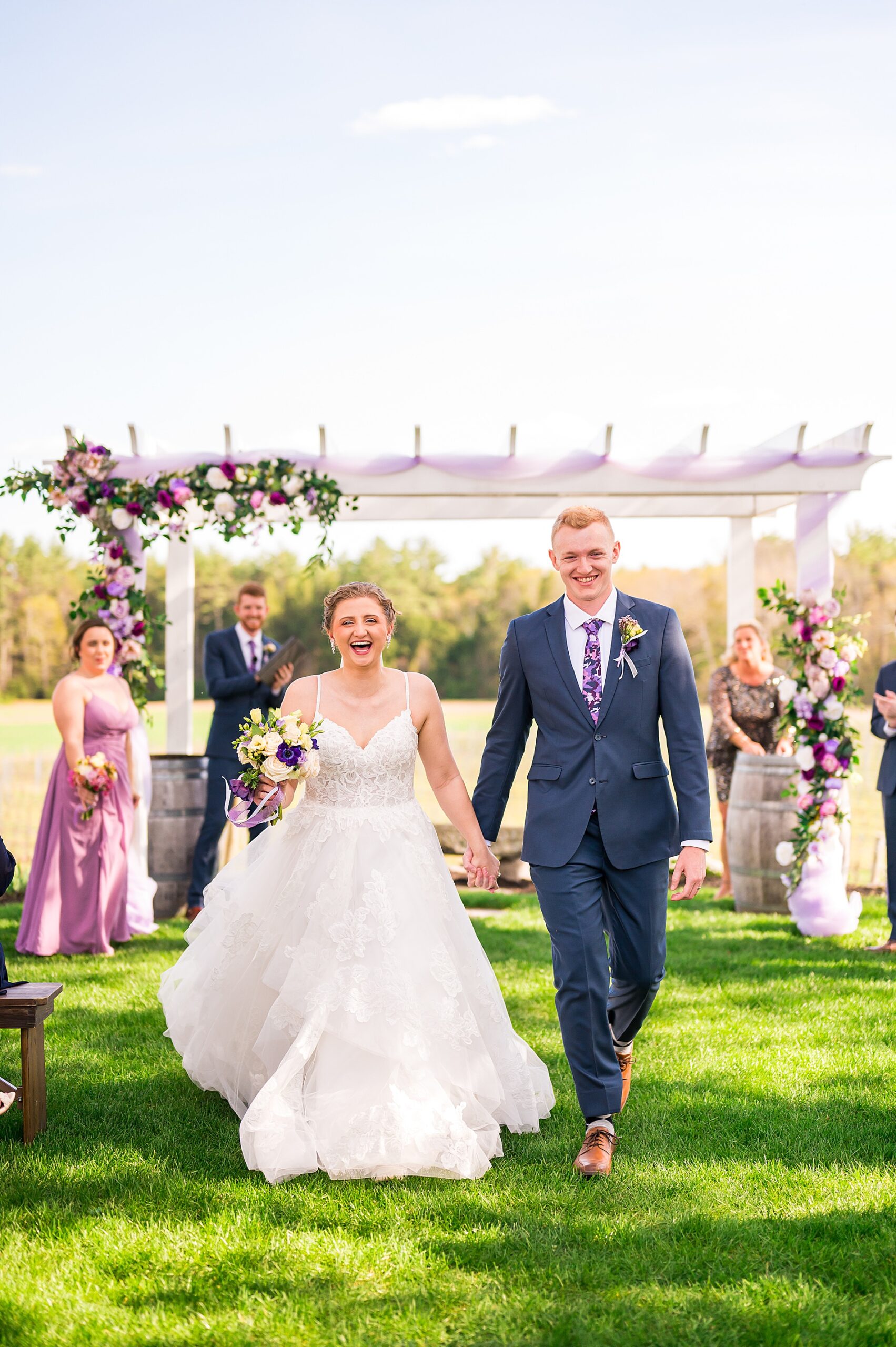 newlyweds hold hands as they walk down the aisle 