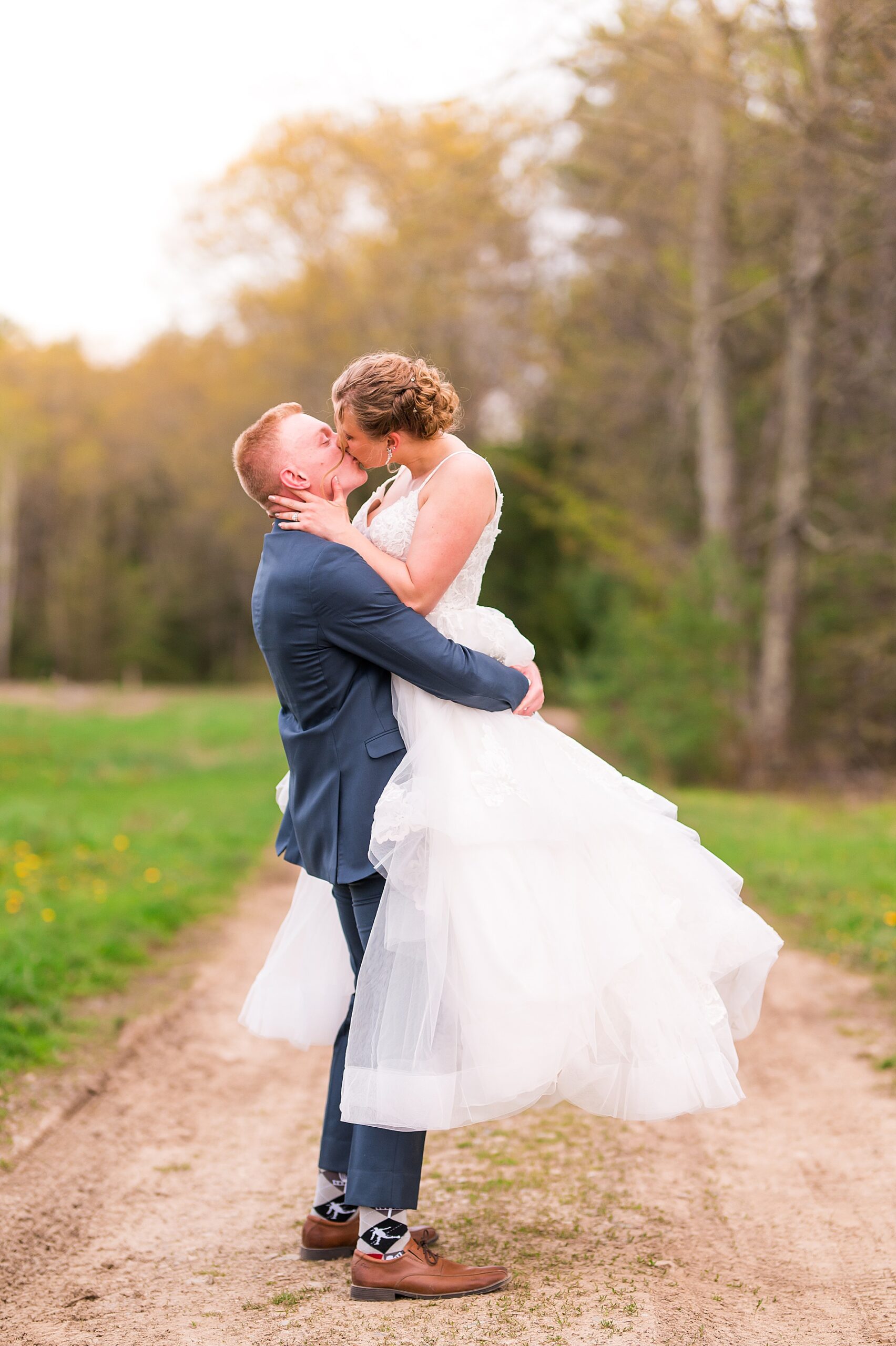 groom lifts up his bride as they kiss