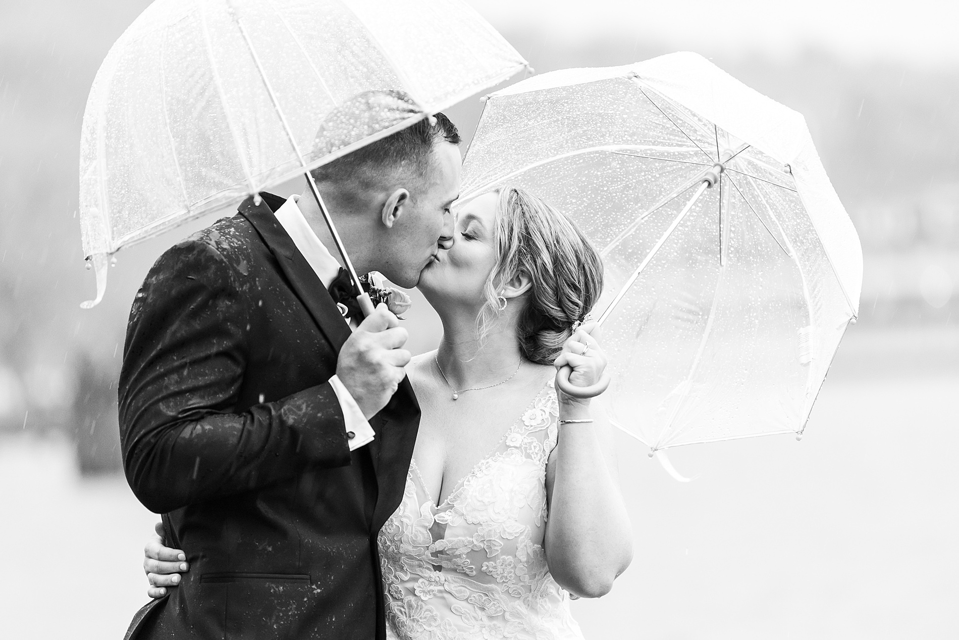 candid wedding portaits of couple holding clear umbrellas